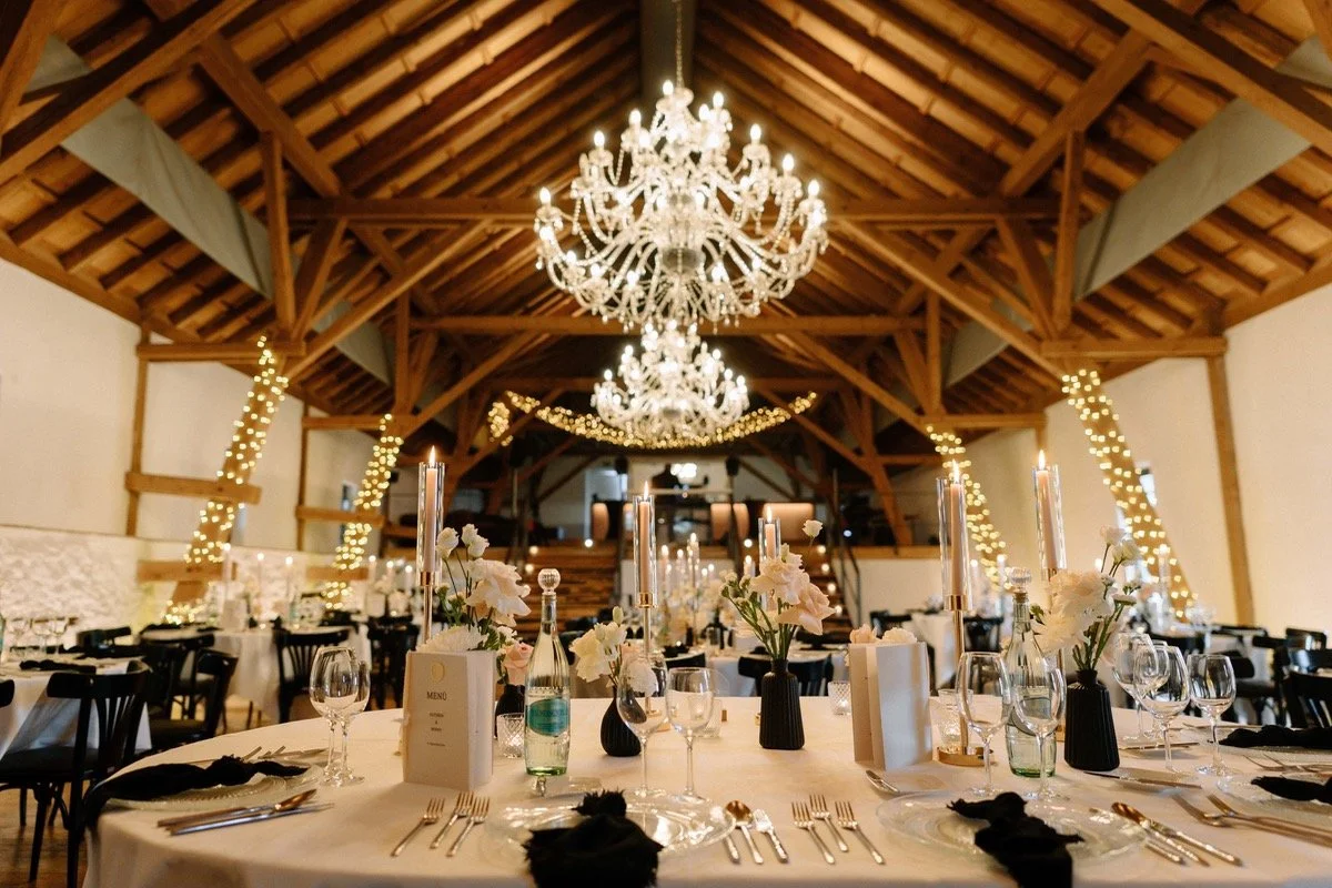 Elegante Festtafel mit Kerzen, Blumen und Kristallleuchtern in einer festlich dekorierten Halle.