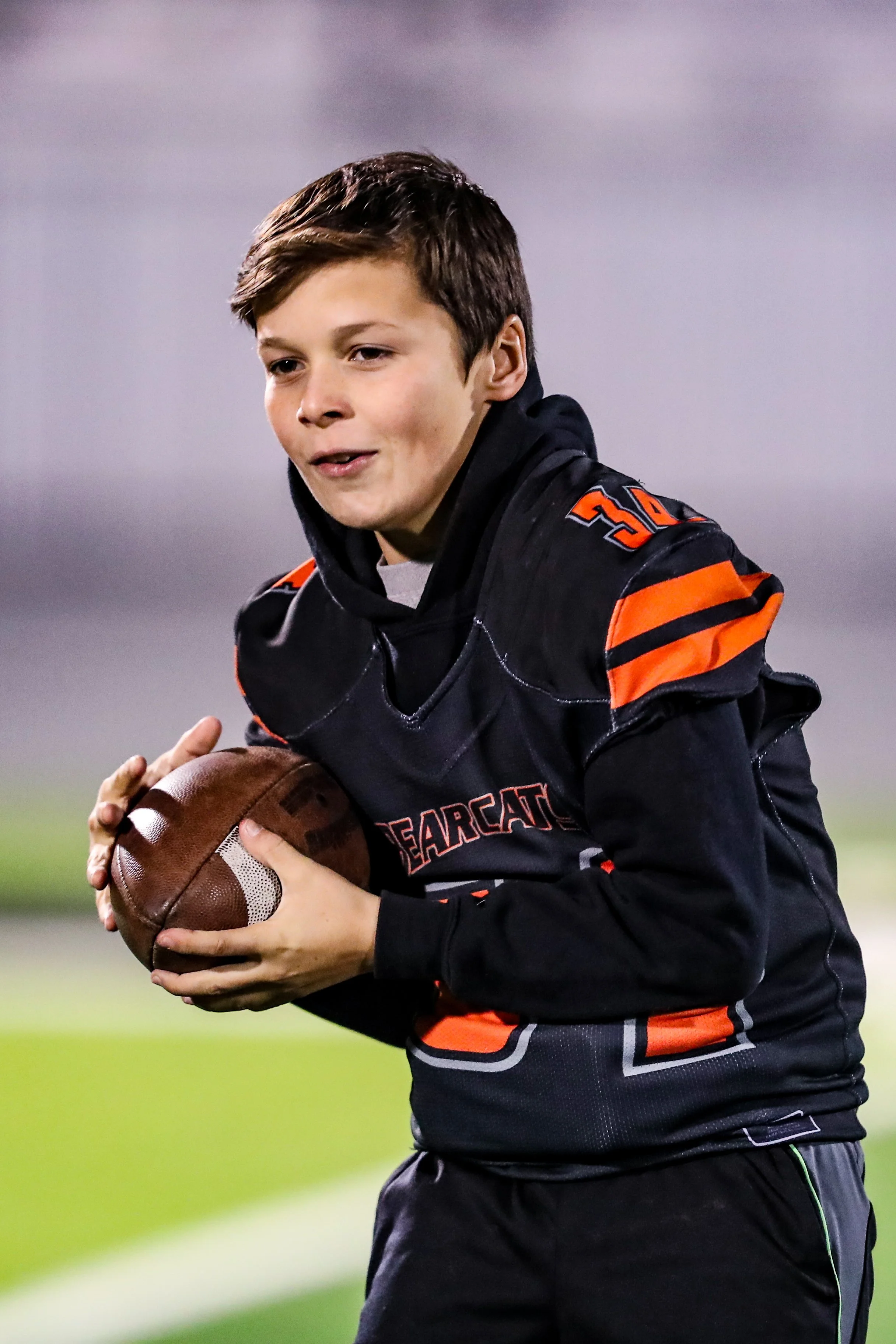 Aledo Middle School football player catching the ball after childhood development chiropractic visit at The Chiropractic Place for Mommy & Me