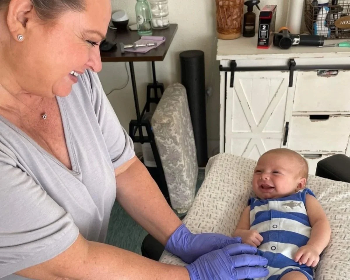 Dr Leslie Hasbini performing a gentle pediatric chiropractic adjustment on an infant at The Chiropractic Place for Mommy and Me in Aledo, Texas