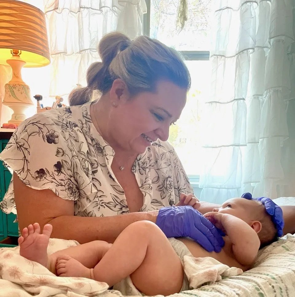 Dr Leslie Hasbini performing pediatric chiropractic adjustment on baby at The Chiropractic Place for Mommy and Me in Aledo, Texas