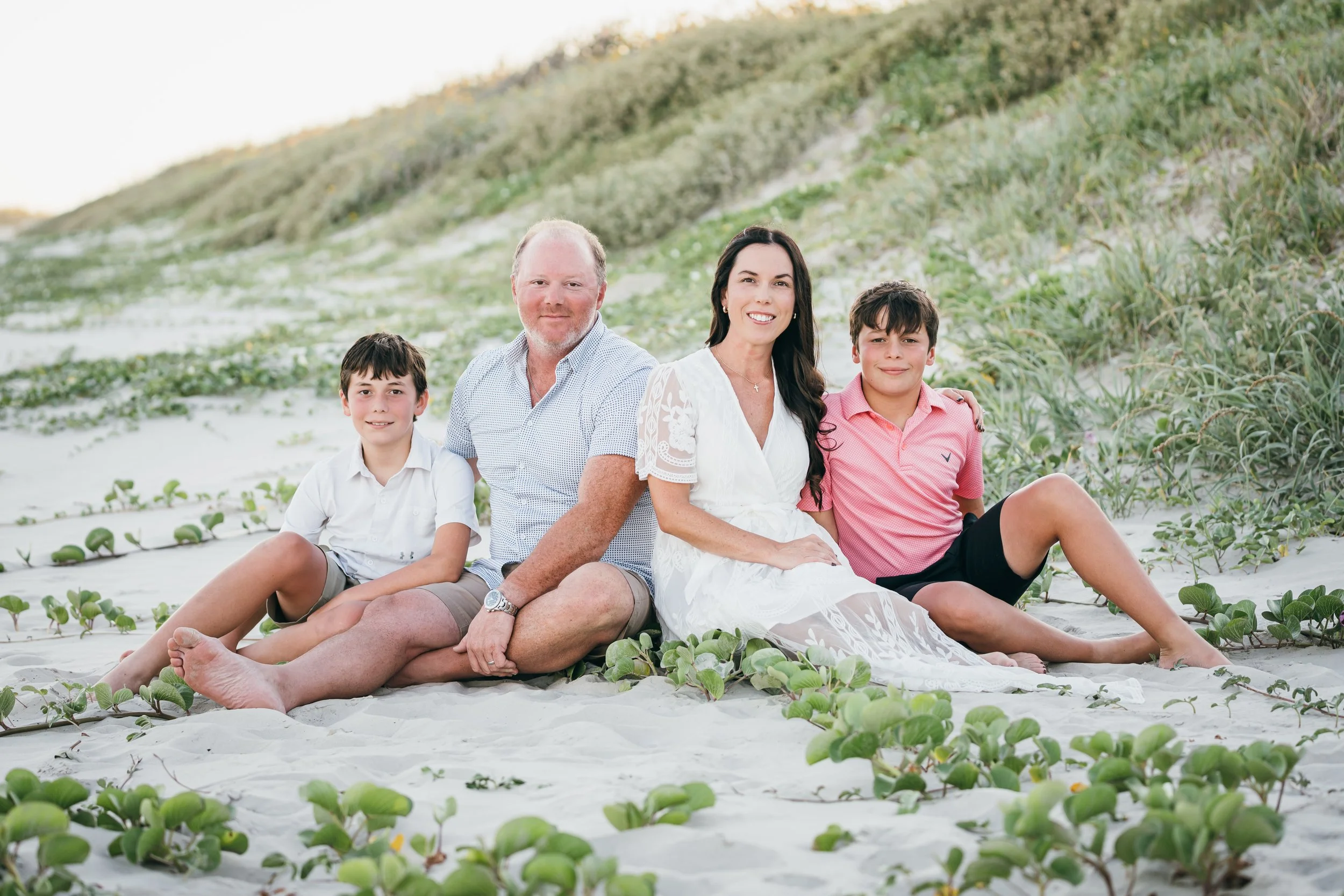 Family sitting happy together on a beach in Texas that work at The Chiropractic Place for Mommy & Me in Aledo