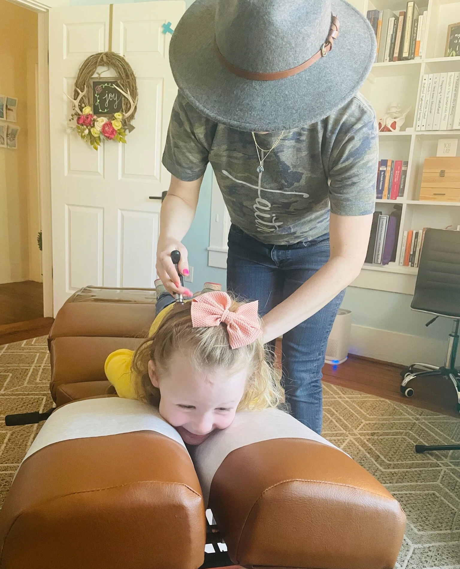 Child receiving pediatric chiropractic adjustment with the Activator that is gentle inside The Chiropractic Place for Mommy & Me in Aledo, TX