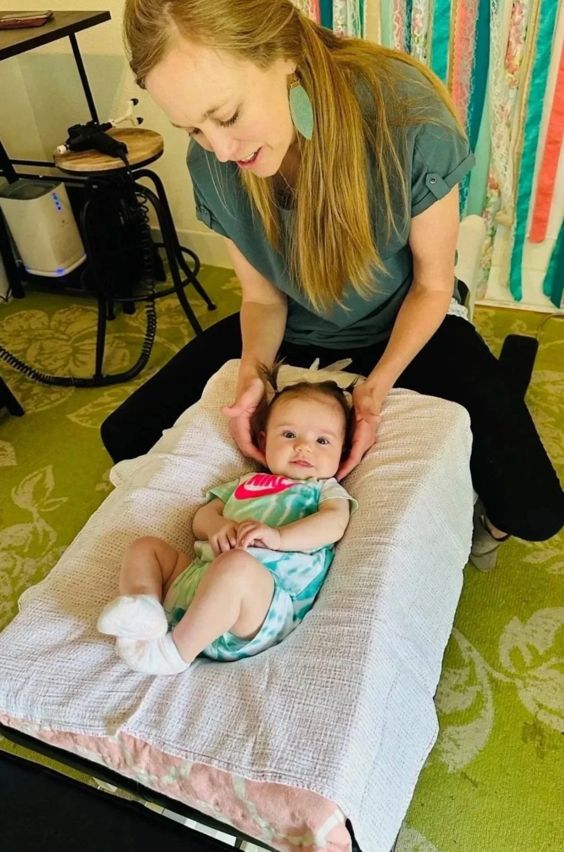 Dr. Kayla Ahlfinger adjusting an infant with gentle, pediatric chiropractic techniques at The Chiropractic Place for Mommy & Me in Aledo, Texas.