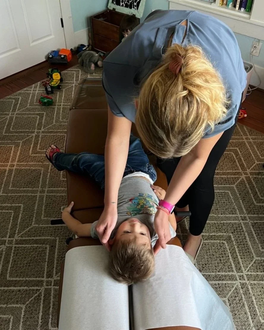 Dr Jessica Faulkenberry adjusting a child on chiropractic table at The Chiropractic Place for Mommy and Me in Aledo, Texas