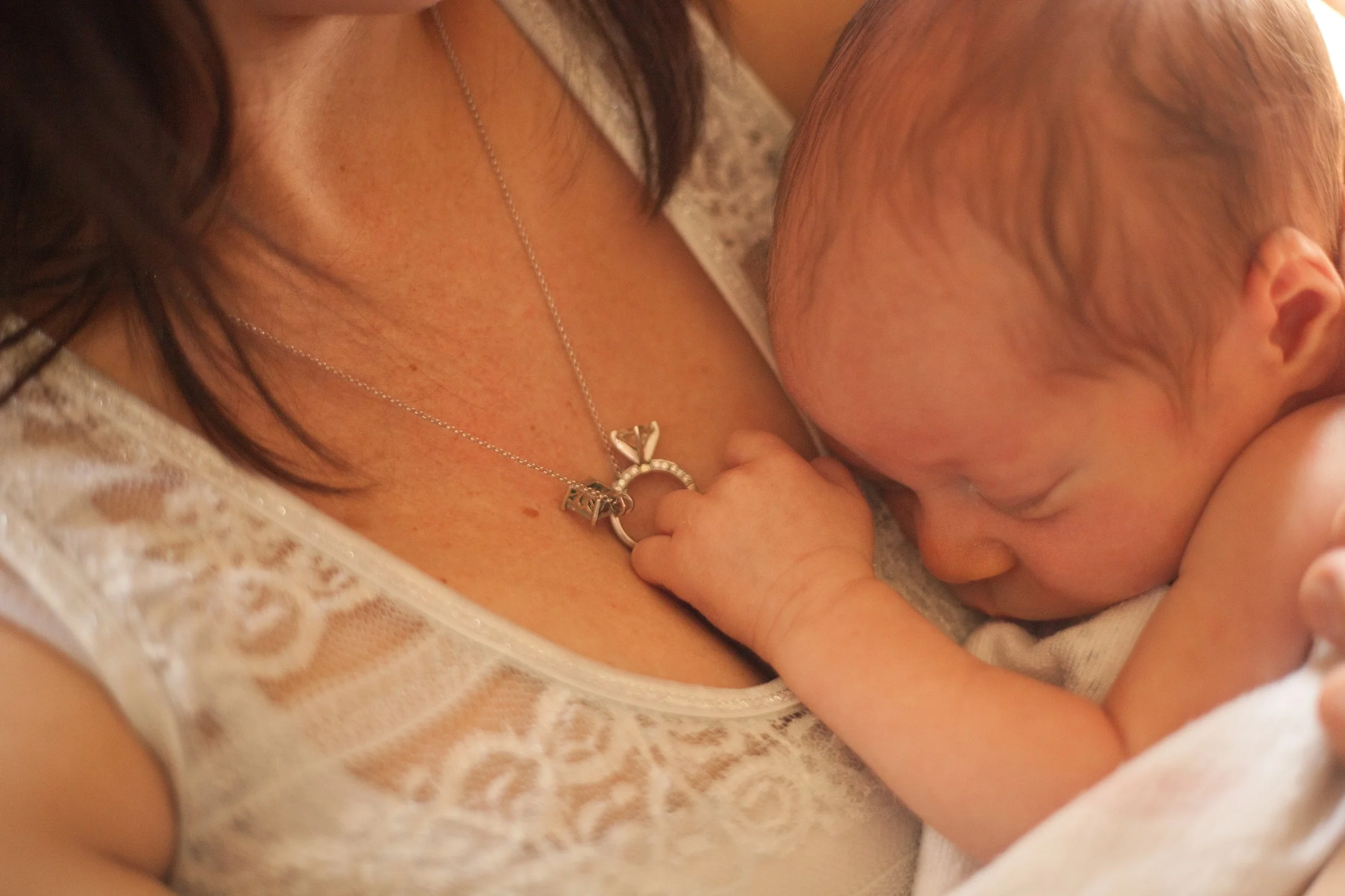 Newly postpartum mom holding her newborn while sitting at The Chiropractic Place for Mommy & Me in Aledo, Texas waiting for her massage