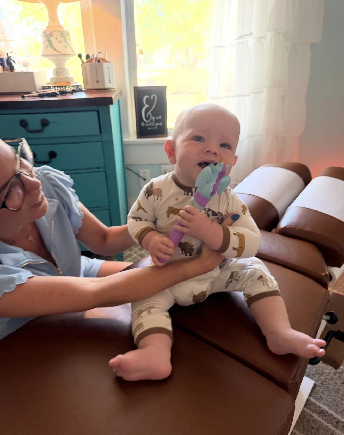 Infant with talk tools vibration wand for oral support during their pediatric chiropractic adjustment at The Chiropractic Place for Mommy & Me in Aledo, TX