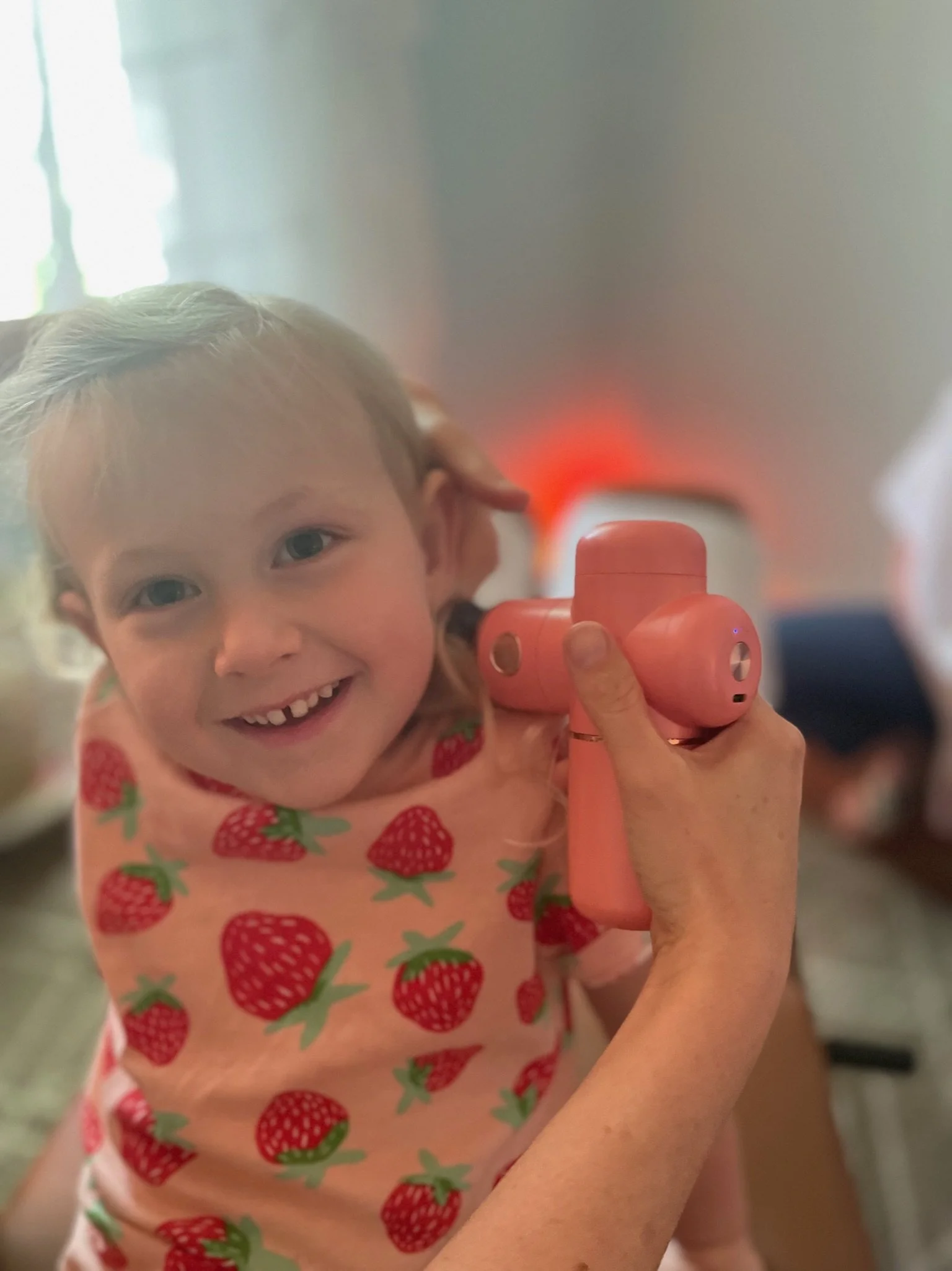 Little girl having the massage gun used during her pediatric chiropractic visit at The Chiropractic Place for Mommy and Me in Aledo, Texas