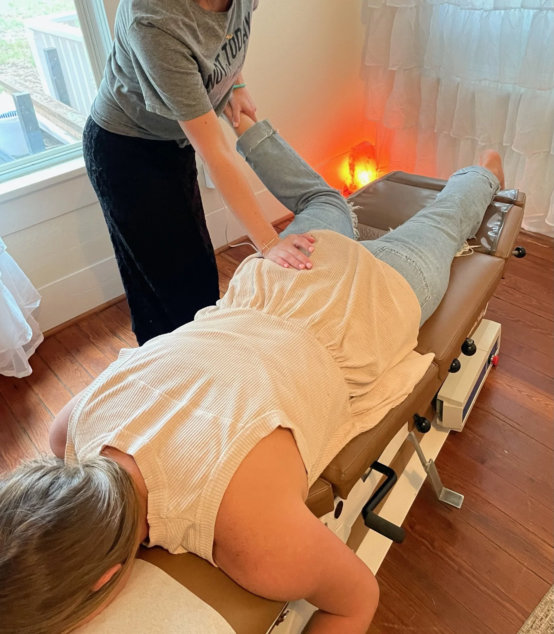 Dr. Michelle Parker stretching the piriformis for sciatica during a woman's family chiropractic visit at The Chiropractic Place for Mommy and Me in Aledo, Texas.