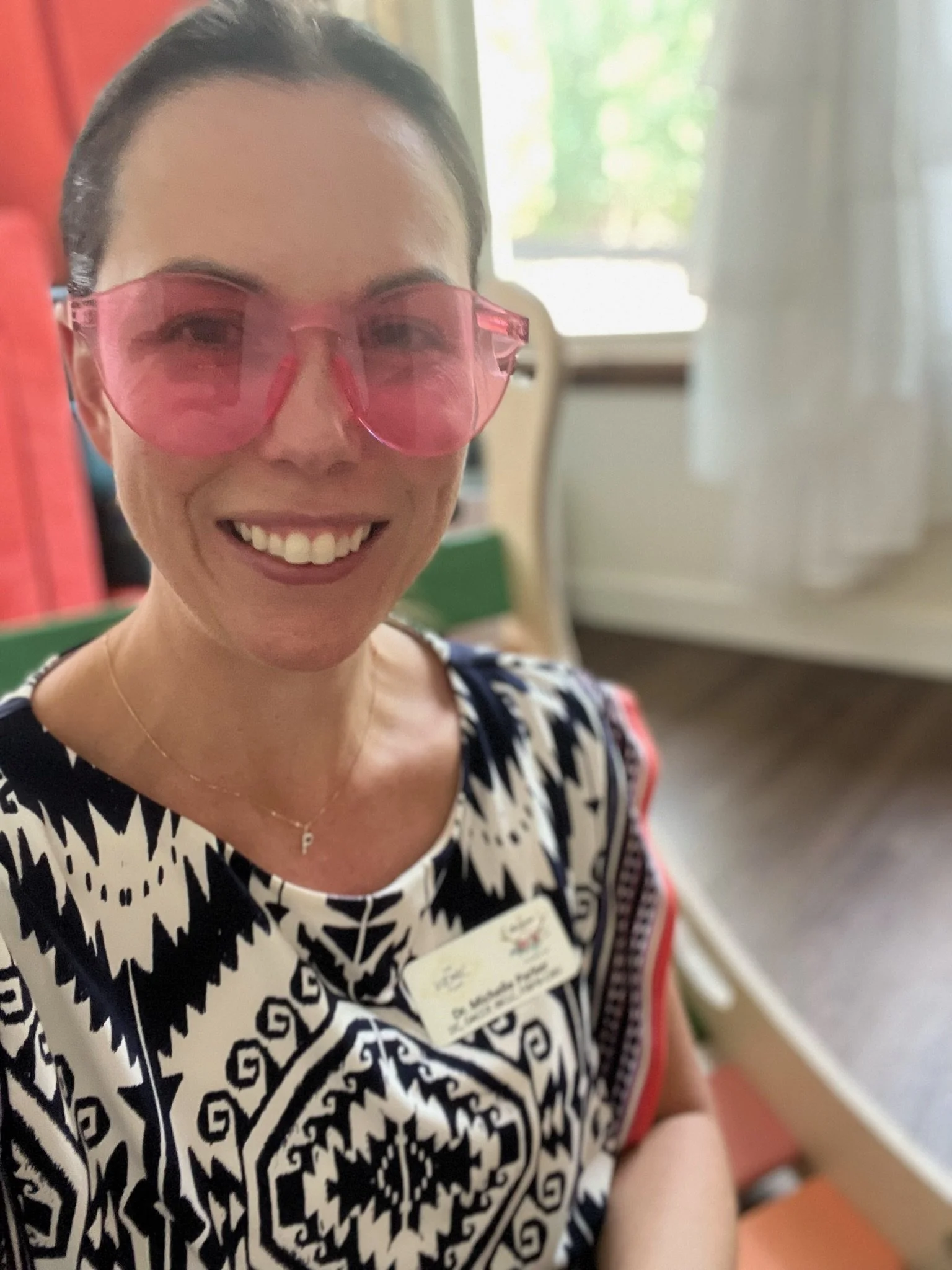 Dr Michelle Parker wearing pink glasses to stimulate the left side of the brain during a developmental chiropractic visit at The Chiropractic Place for Mommy and Me in Aledo, Texas