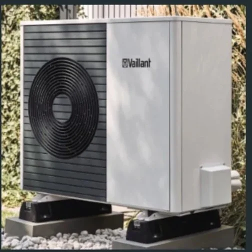 Black and white photo of an old, vertical radiator heater on a wall.