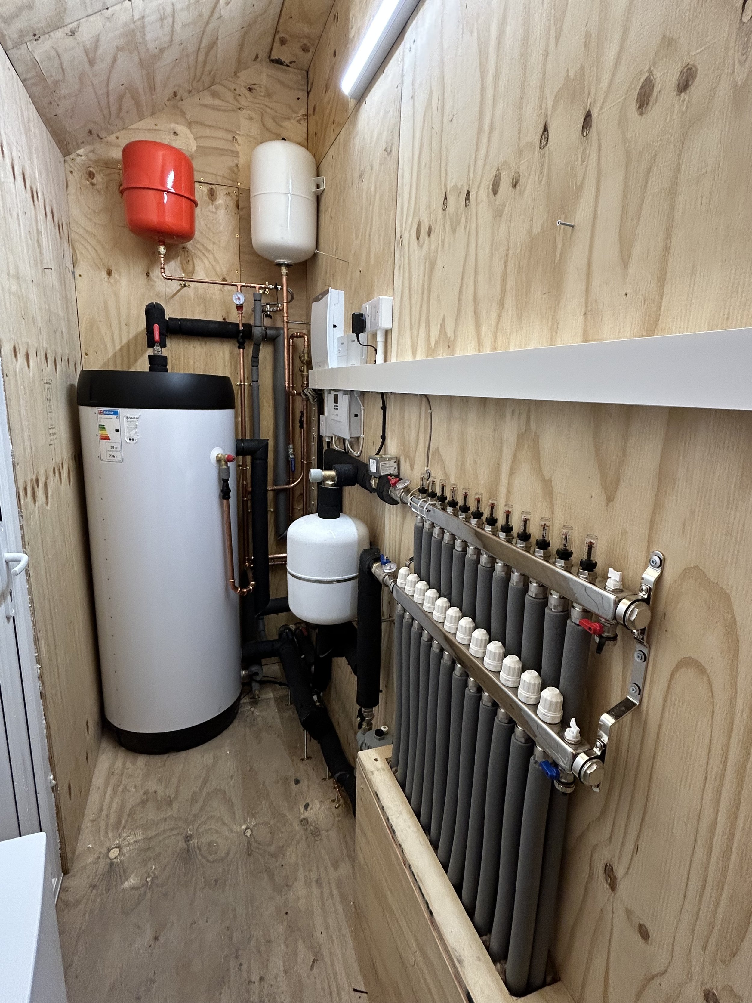 Custom-built plant room housing the ASHP equipment, hot water cylinder and UFH manifold