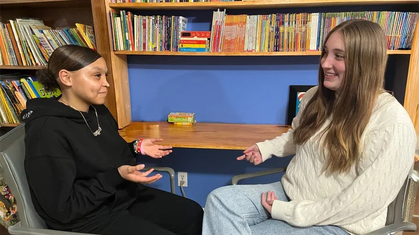 Girl sitting across female counselor engaging in conversation