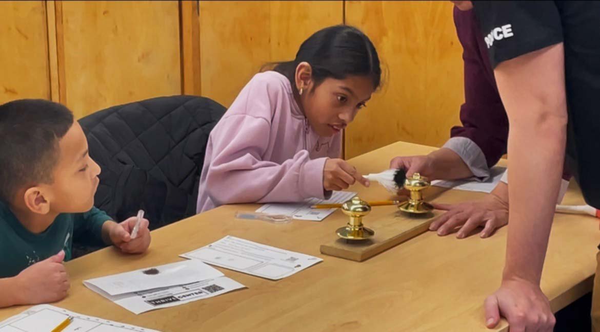 A student from the forensic science club developing latent fingerprints during a lab exercise.