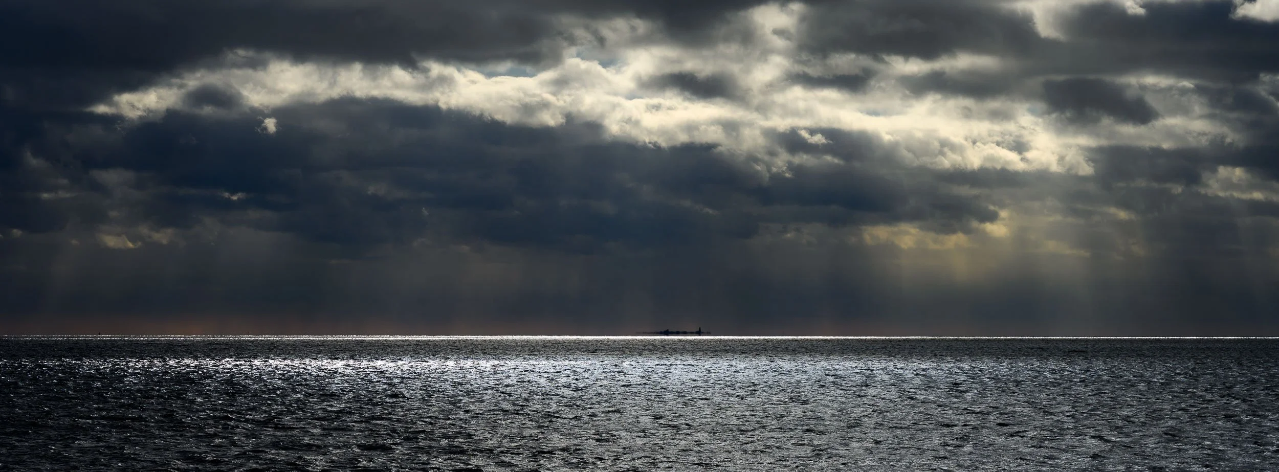 Distant island under a great sky, and dark sea.jpg
