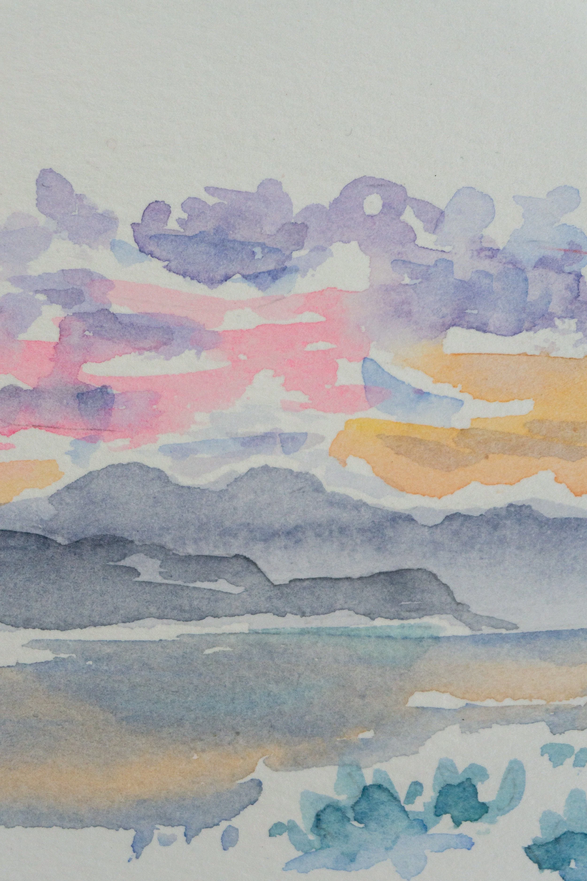 Watercolor landscape of a coastal scene with colorful sky, mountains, and ocean.