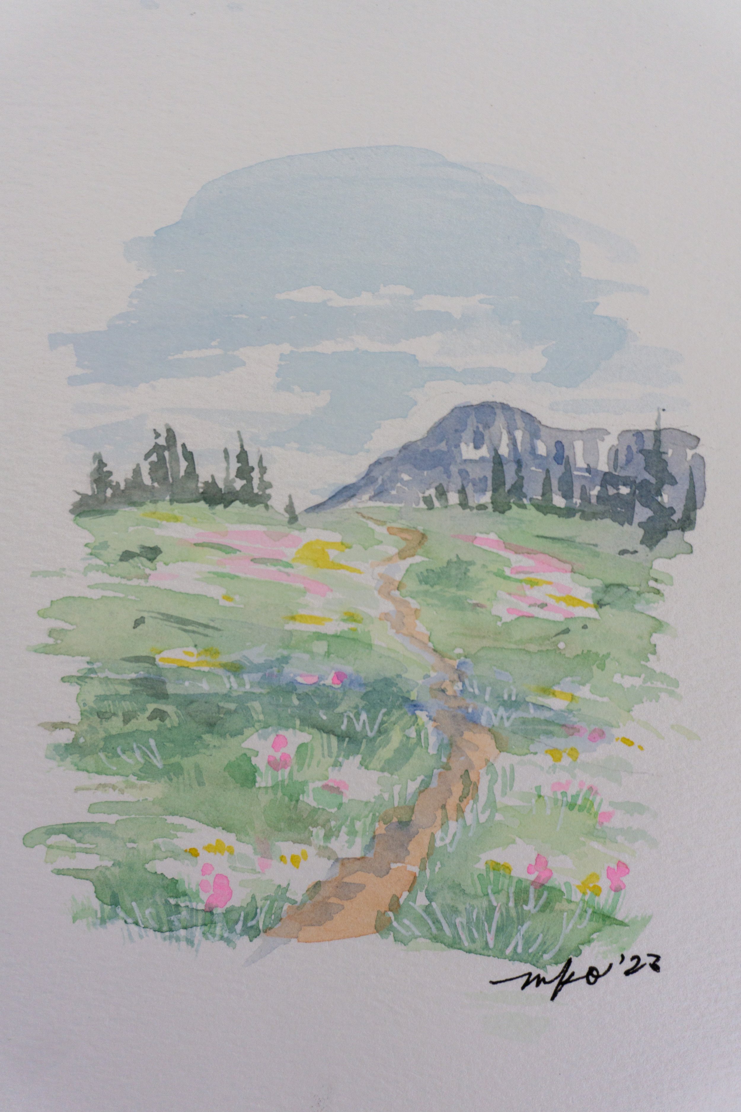 Watercolor painting of a serene landscape featuring a mountain path leading through a field of colorful wildflowers with pine trees and a mountain in the background.