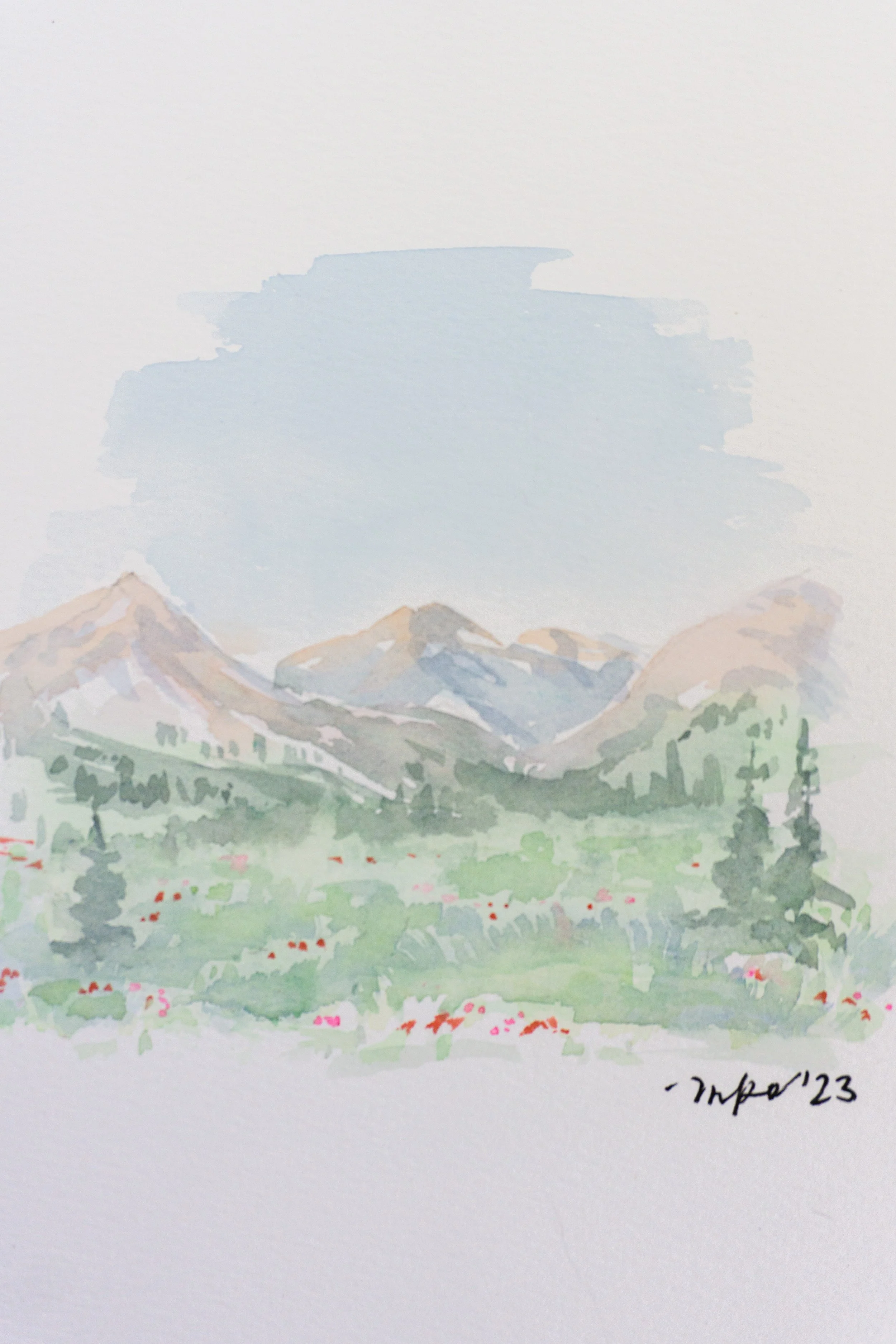 Watercolor painting of a mountain landscape with trees and flowers.