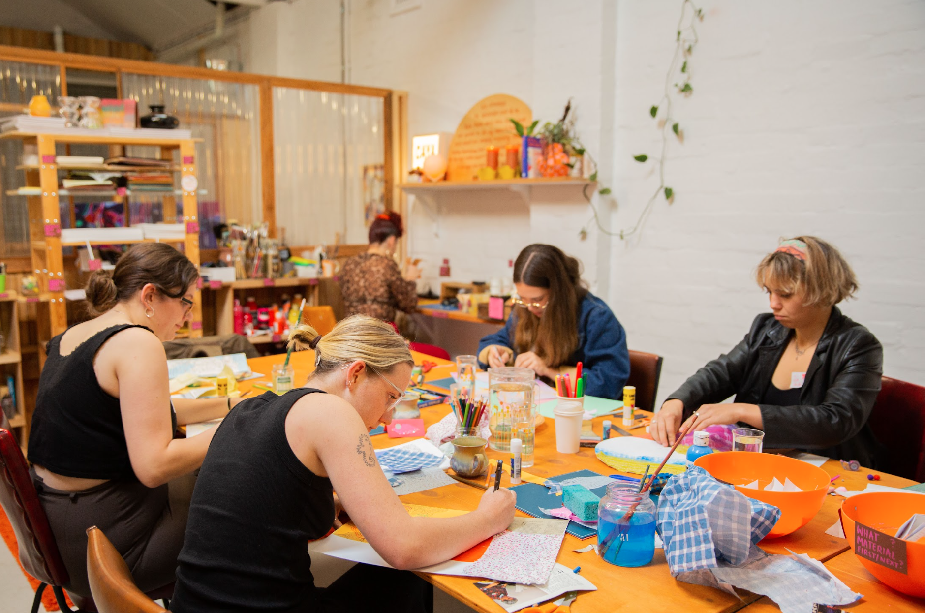 Group of people engaged in arts and crafts activities in a creative studio environment.