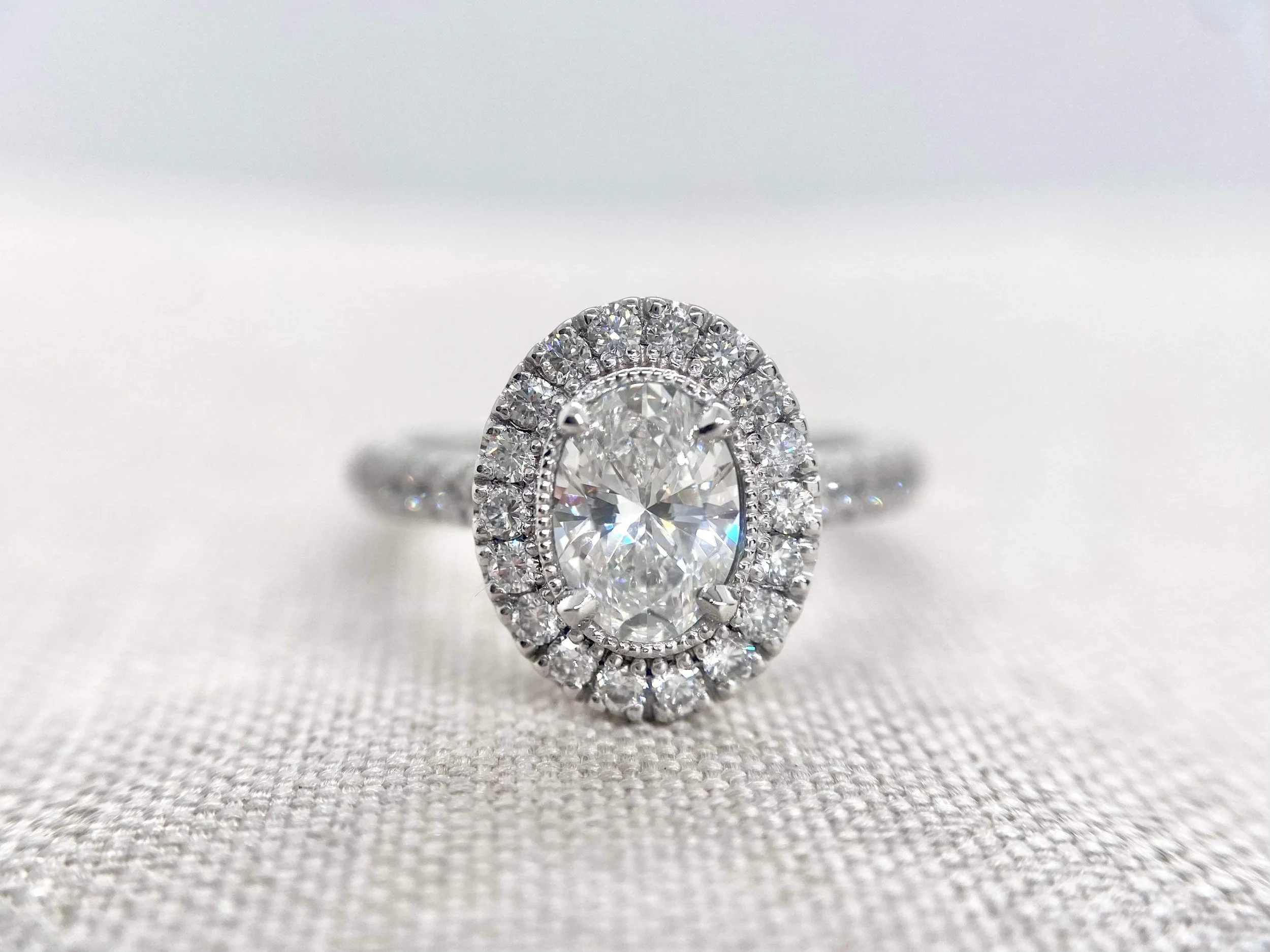 18ct white gold engagement ring, oval centre stone, milgrain setting.