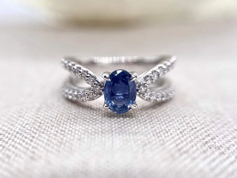 18ct white gold cocktail ring set set with an oval cut blue sapphire and 76pts of round brilliant cut diamonds.