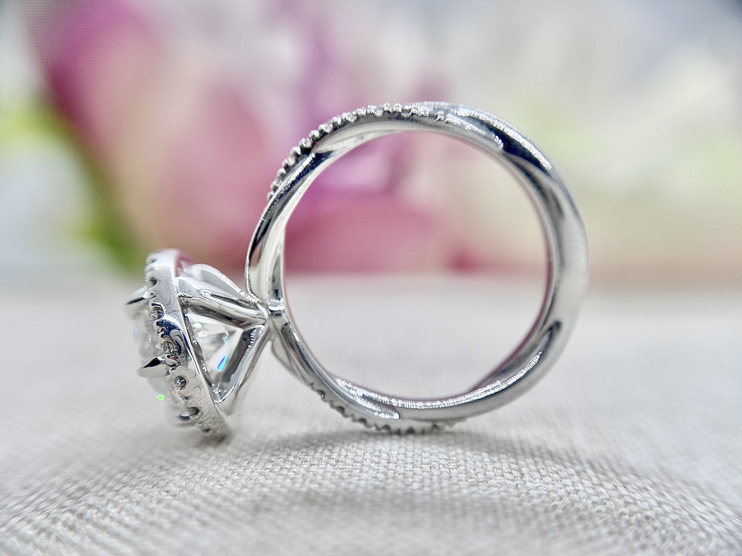 18ct white gold ring featuring a 1.84ct round brilliant cut diamond and diamond halo, sitting on a rope twisted diamond set band.