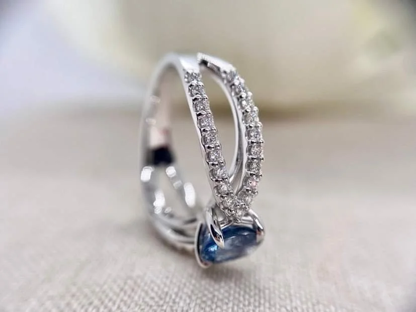 18ct white gold cocktail ring set set with an oval cut blue sapphire and 76pts of round brilliant cut diamonds.