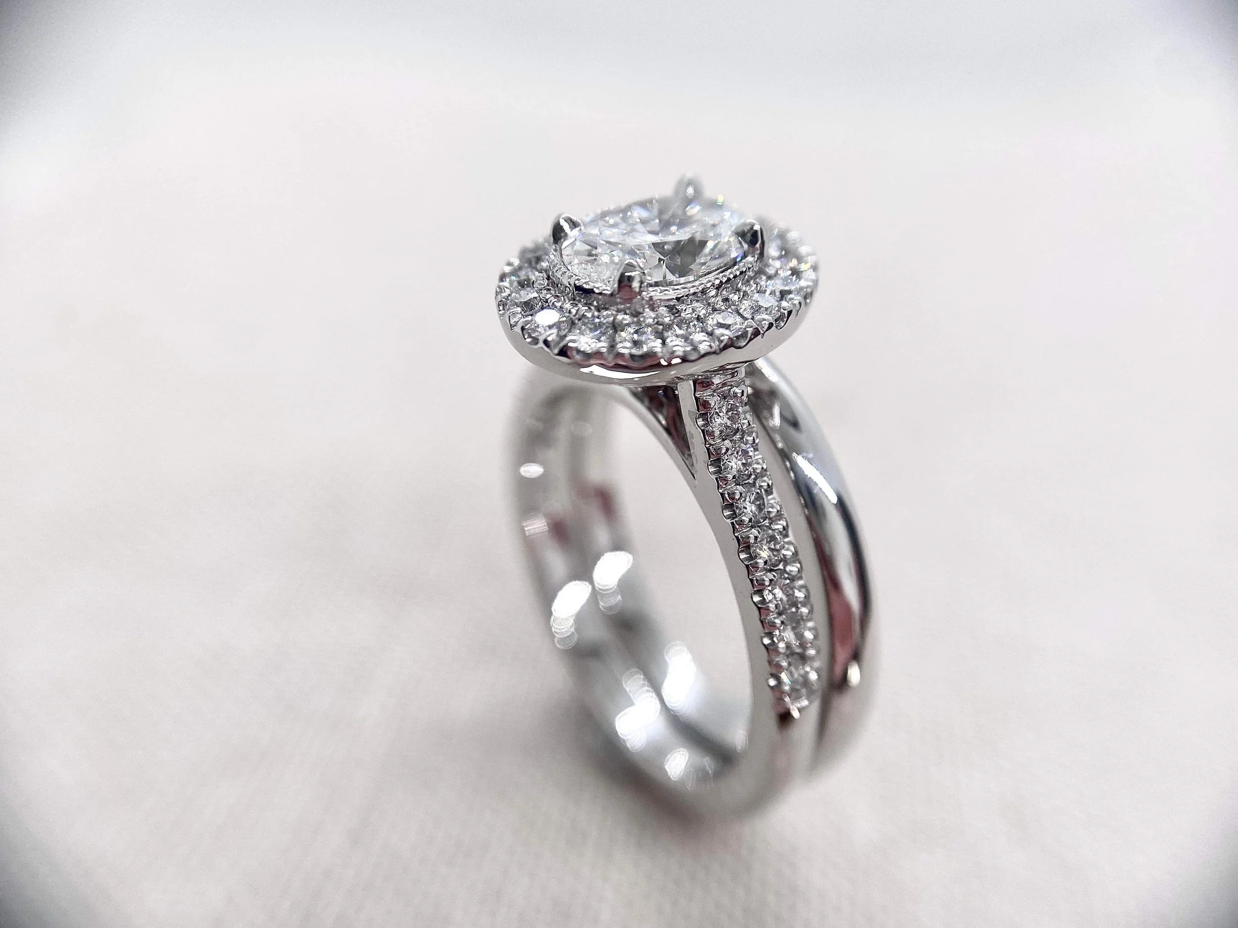18ct white gold engagement ring, oval centre stone, milgrain setting. Straight half round wedder.