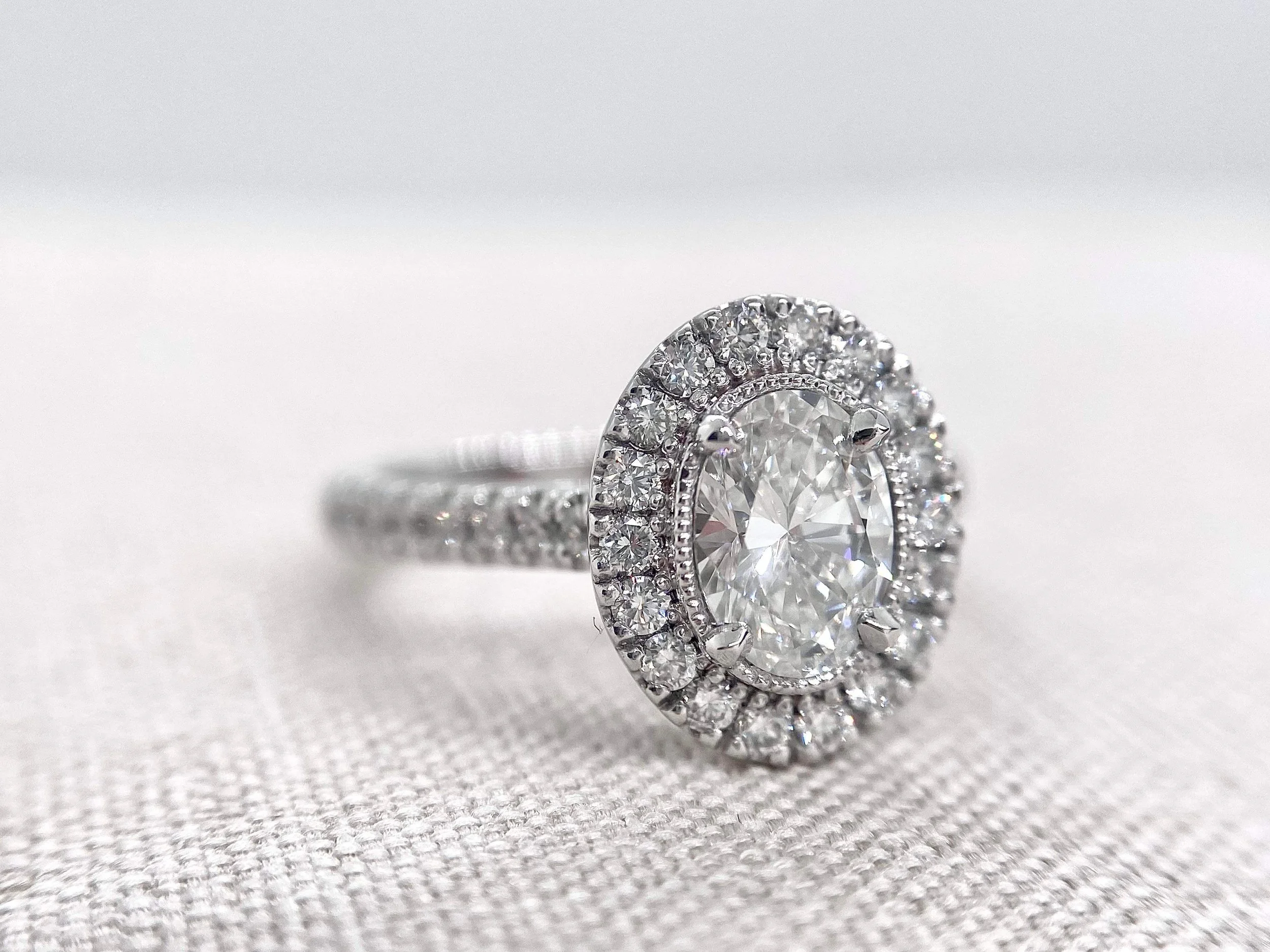 18ct white gold engagement ring, oval centre stone, milgrain setting.