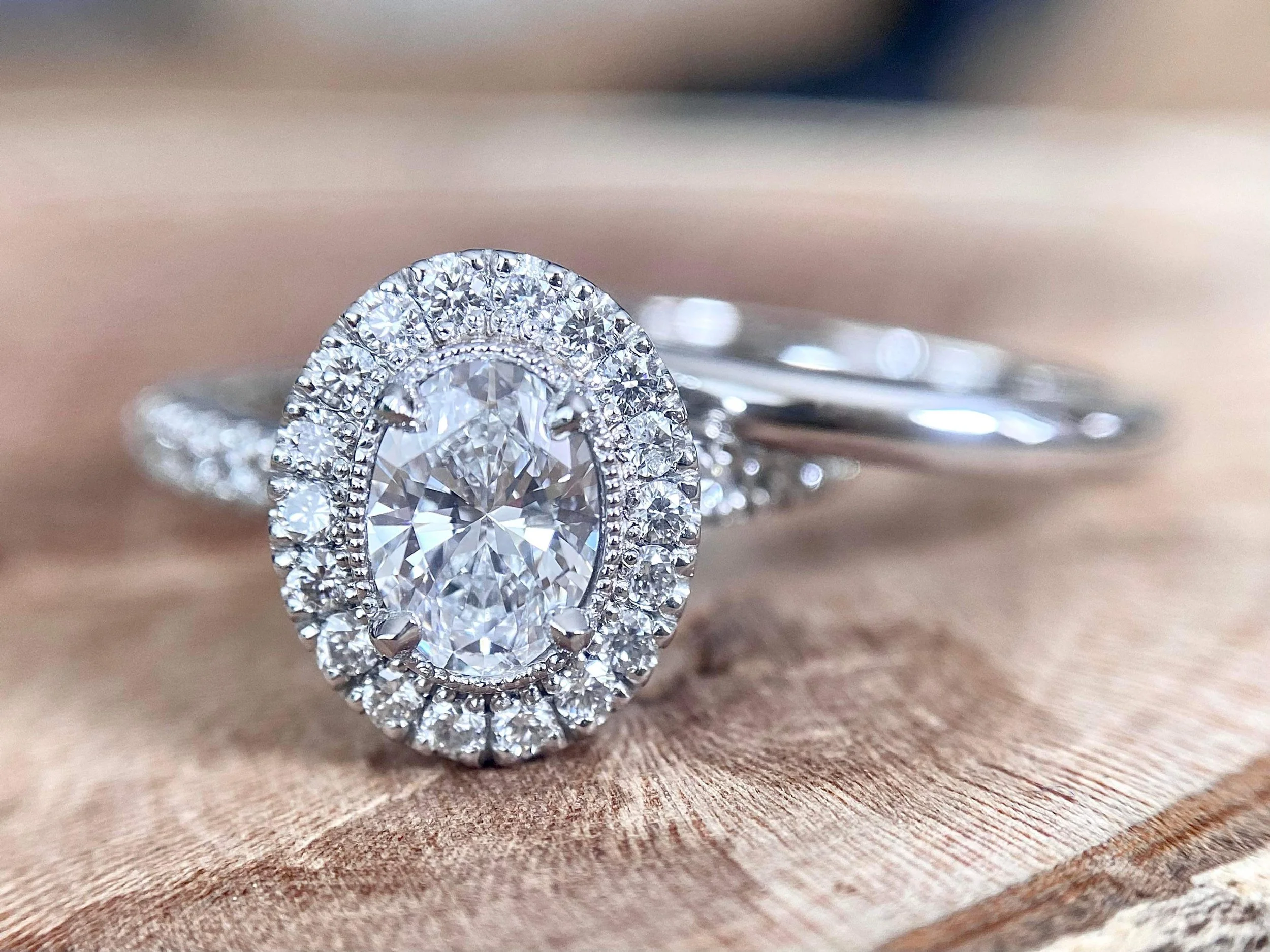 18ct white gold engagement ring, oval centre stone, milgrain setting.