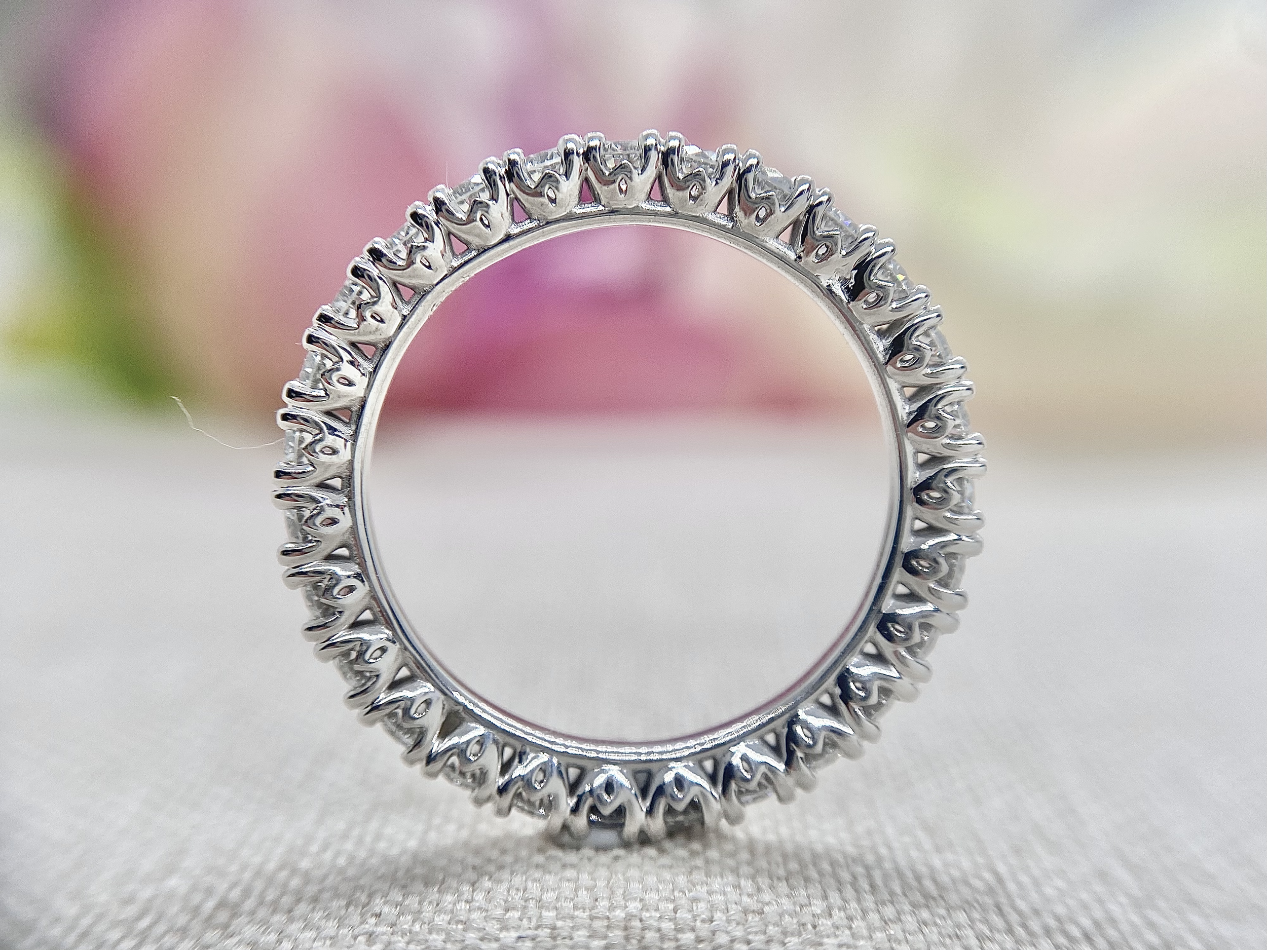 18ct white gold full circle diamond wedder featuring 9pt round brilliant cut diamonds and a tulip setting detail.