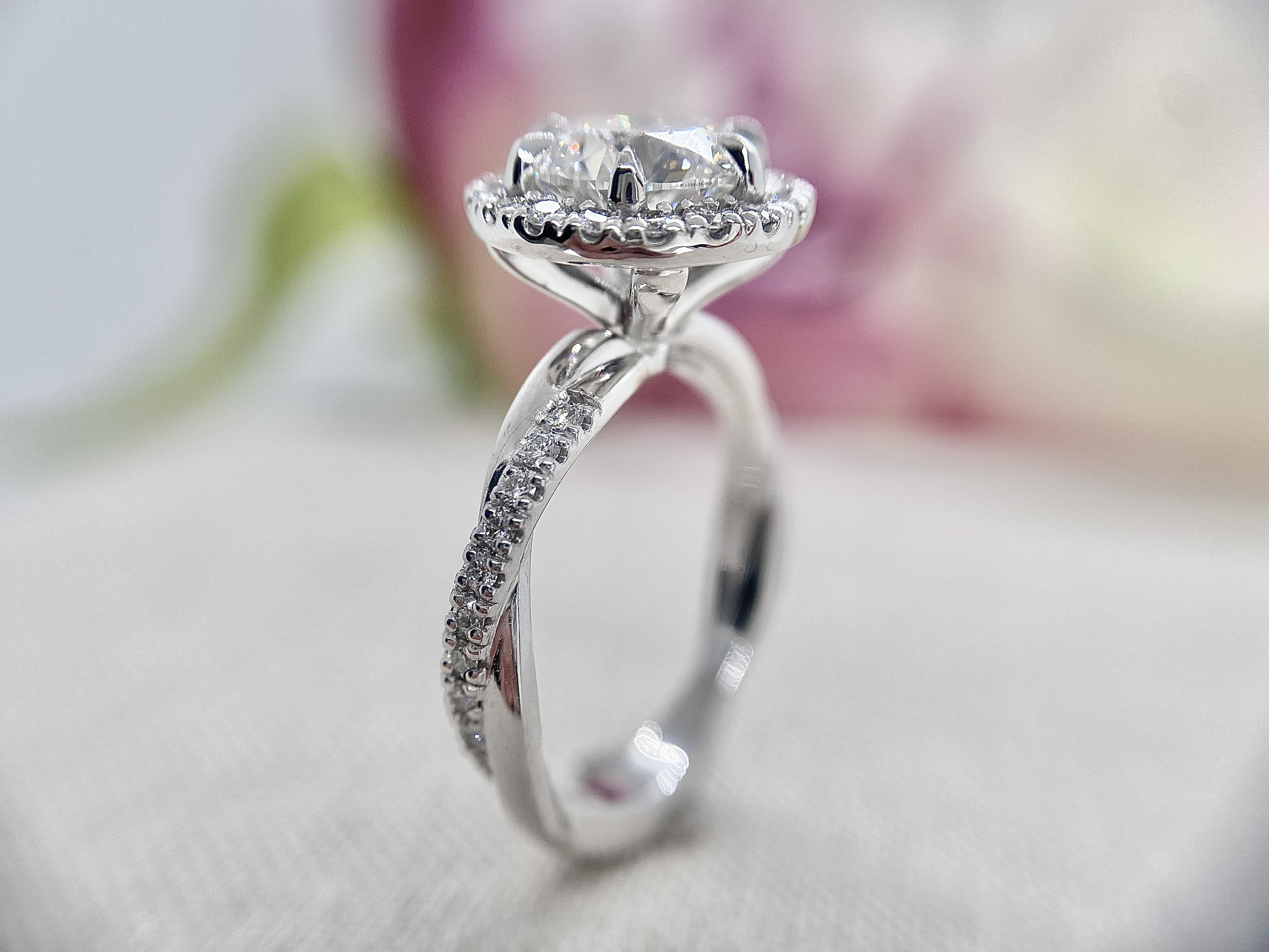 18ct white gold ring featuring a 1.84ct round brilliant cut diamond and diamond halo, sitting on a rope twisted diamond set band.