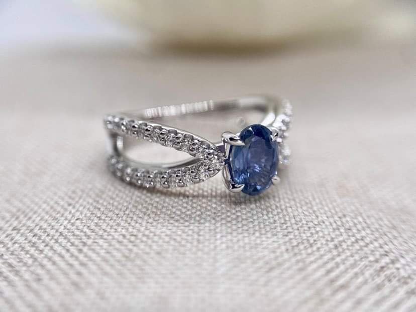 18ct white gold cocktail ring set set with an oval cut blue sapphire and 76pts of round brilliant cut diamonds.