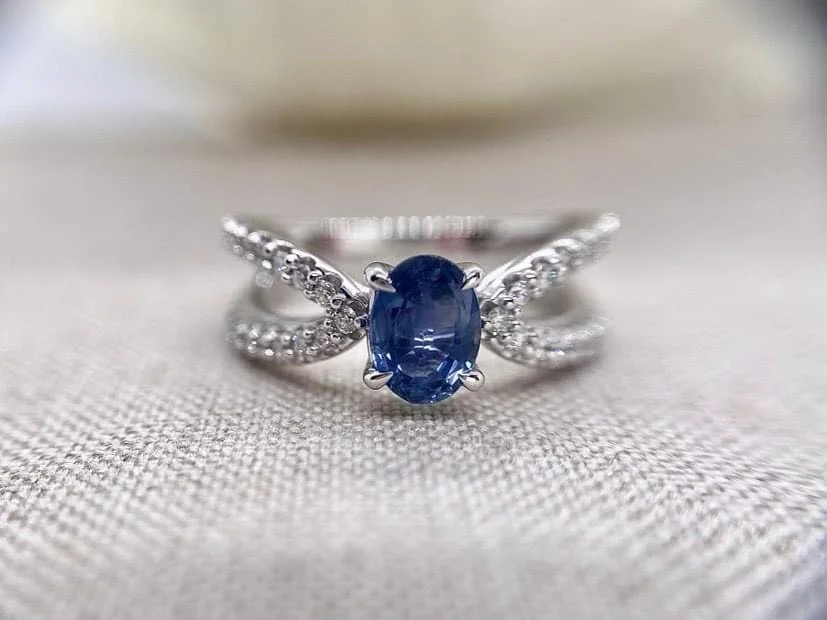 18ct white gold cocktail ring set set with an oval cut blue sapphire and 76pts of round brilliant cut diamonds.
