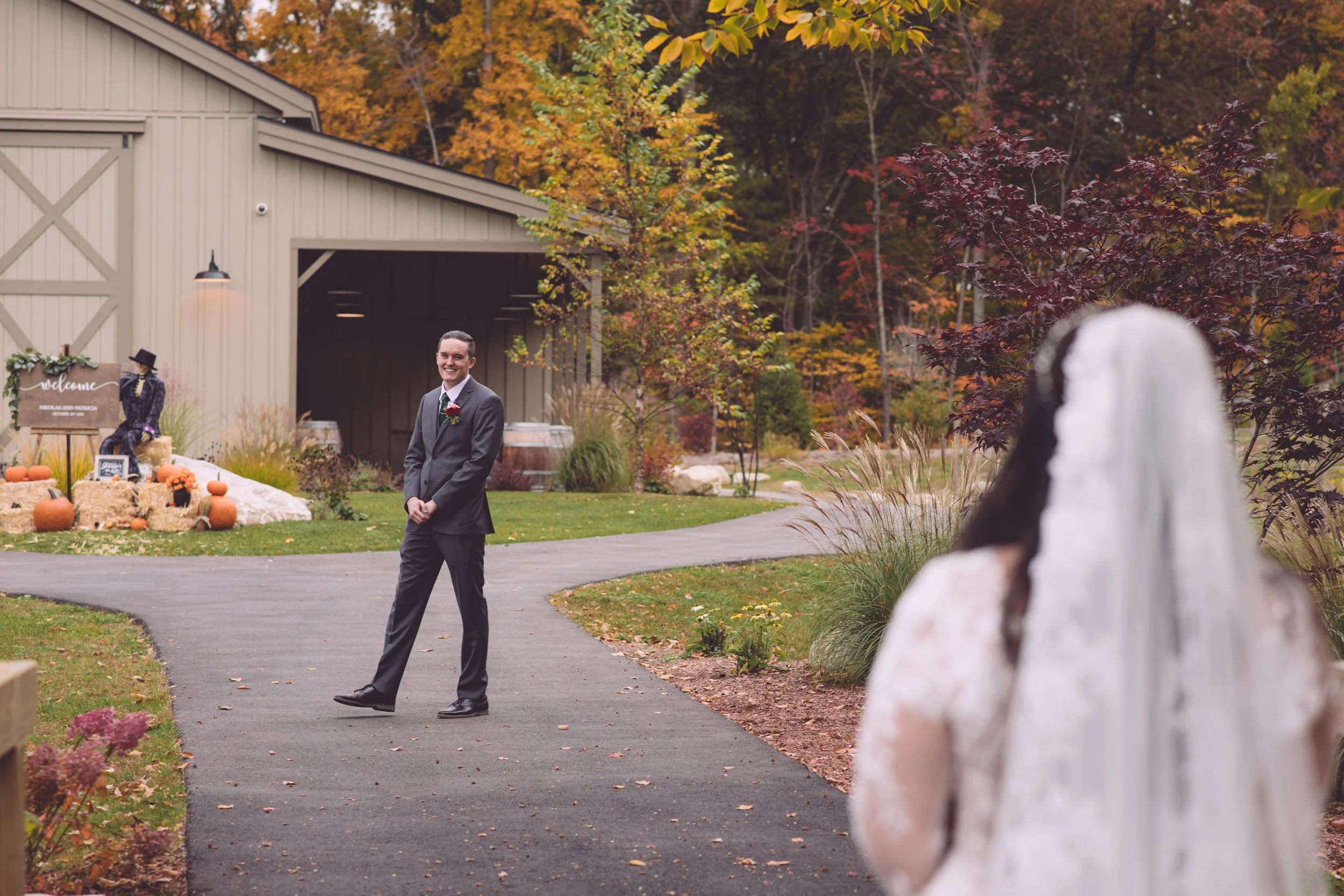 A loving groom turning and approaching his beautiful bride during their first look at their wedding at LaBelle Winery in Derry, NH. Wedding photography by Mike Indi.