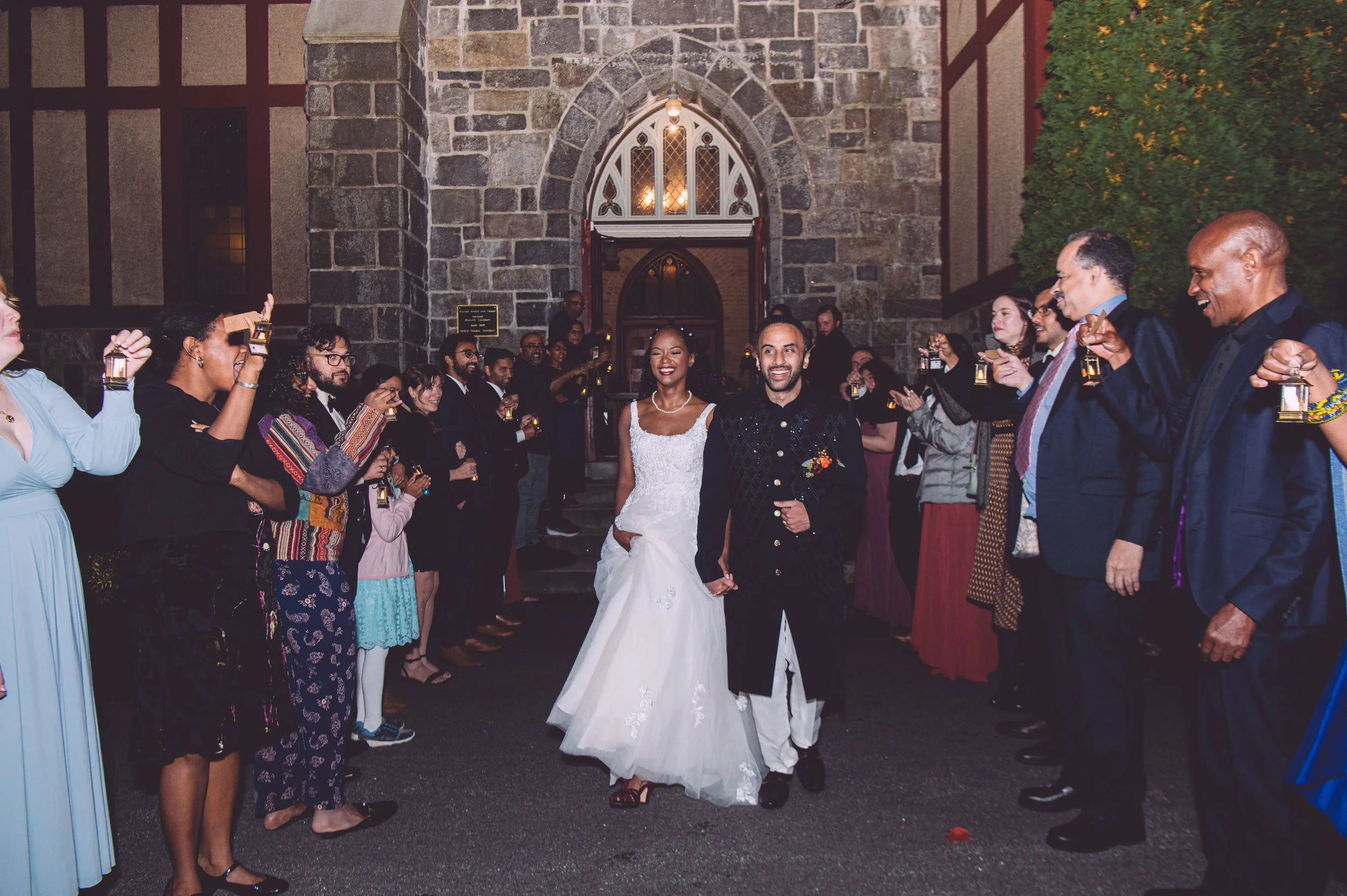A bride and groom laughing during their grand exit from their wedding reception at Searles Chapel in Windham, NH. Wedding photography by Mike Indi.