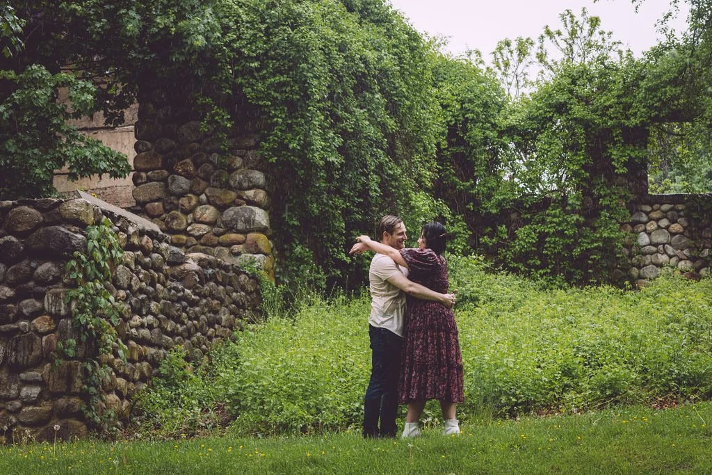 Chelsea and Ryan in a passionate embrace during their spring engagement session in the pouring rain at Bancroft's Castle in Groton, MA. Photography by Mike Indi.