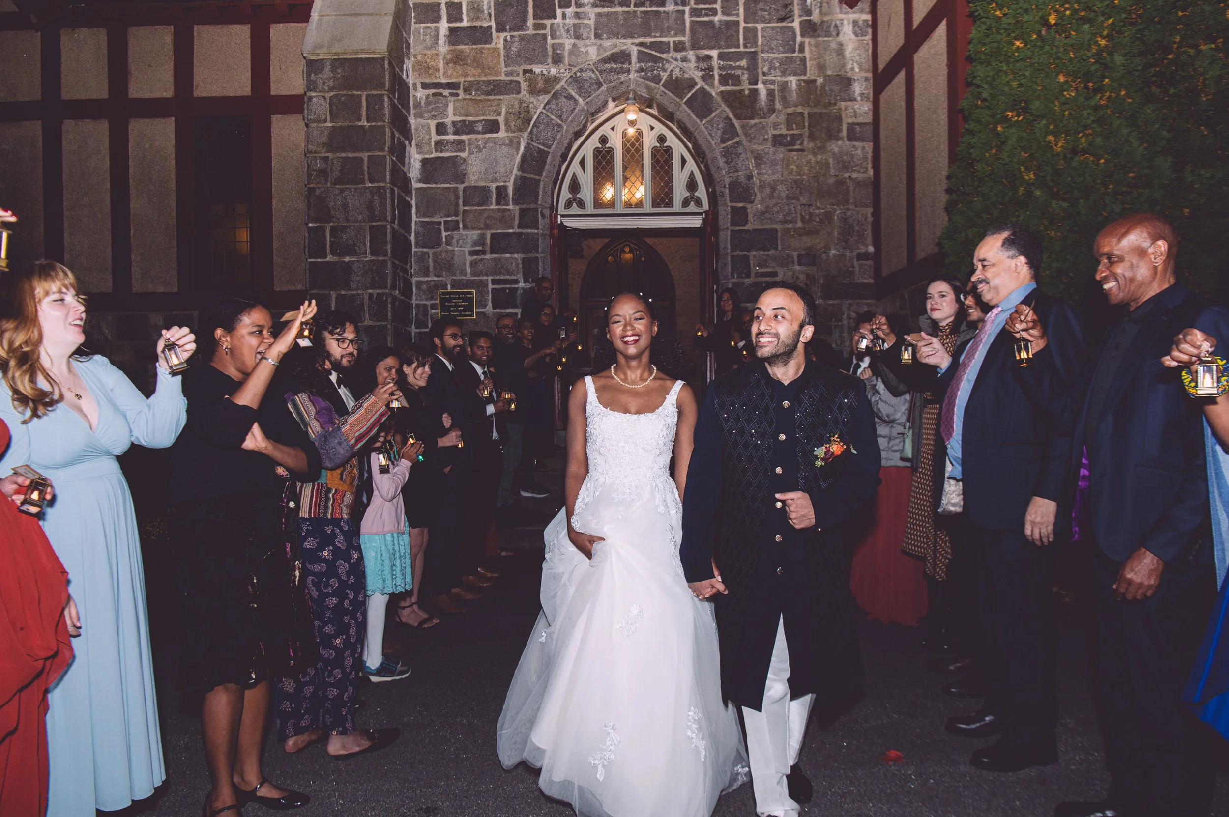 A bride and groom laughing during their grand exit from their wedding reception at Searles Chapel in Windham, NH. Wedding photography by Mike Indi.