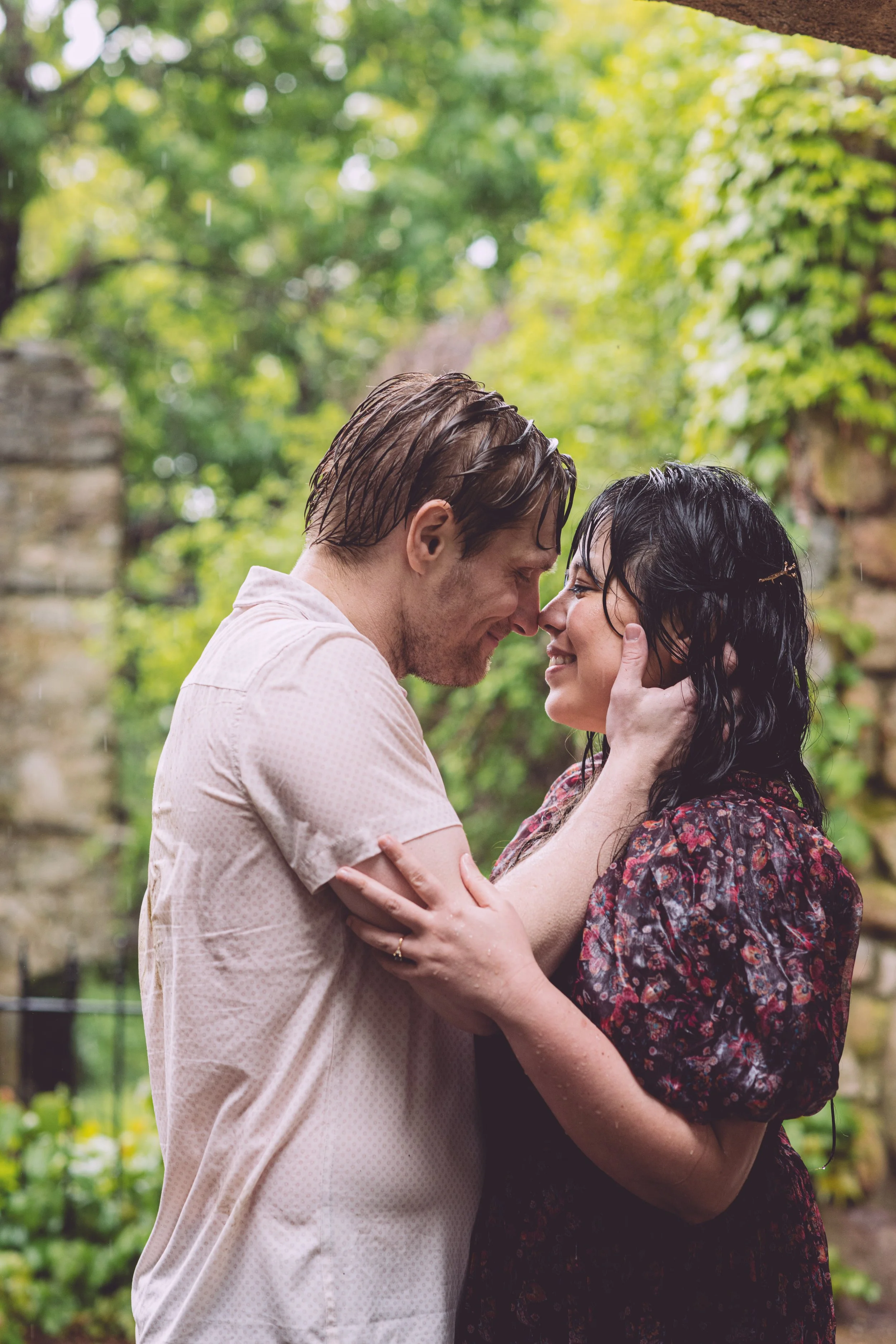 A rain soaked couple in a passionate embrace during their rainy engagement session at Bancroft's Castle in Groton, MA. Engagement photography by Mike Indi.