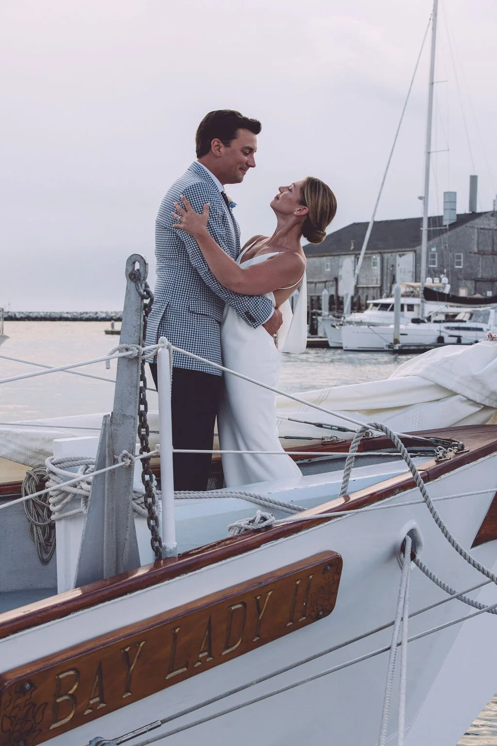 Amanda and Christopher sharing a passionate embrace aboard the Bay Lady II during their sunset sail adventure elopement in Provincetown, MA. Photography by Mike Indi.