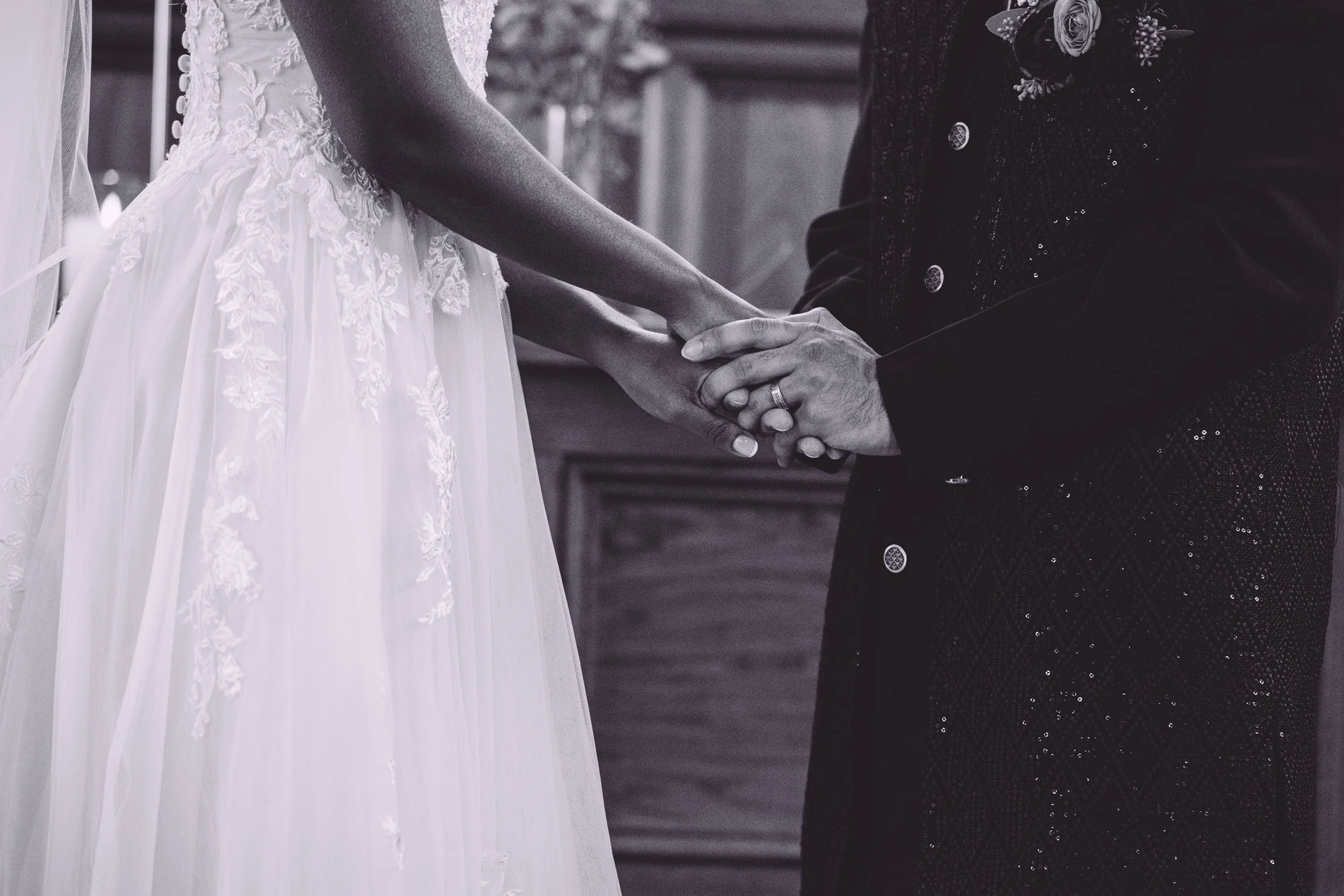 A bride placing a wedding ring on her groom's hand during their wedding ceremony at Searles Chapel in Windham, NH. Wedding photography by Mike Indi.