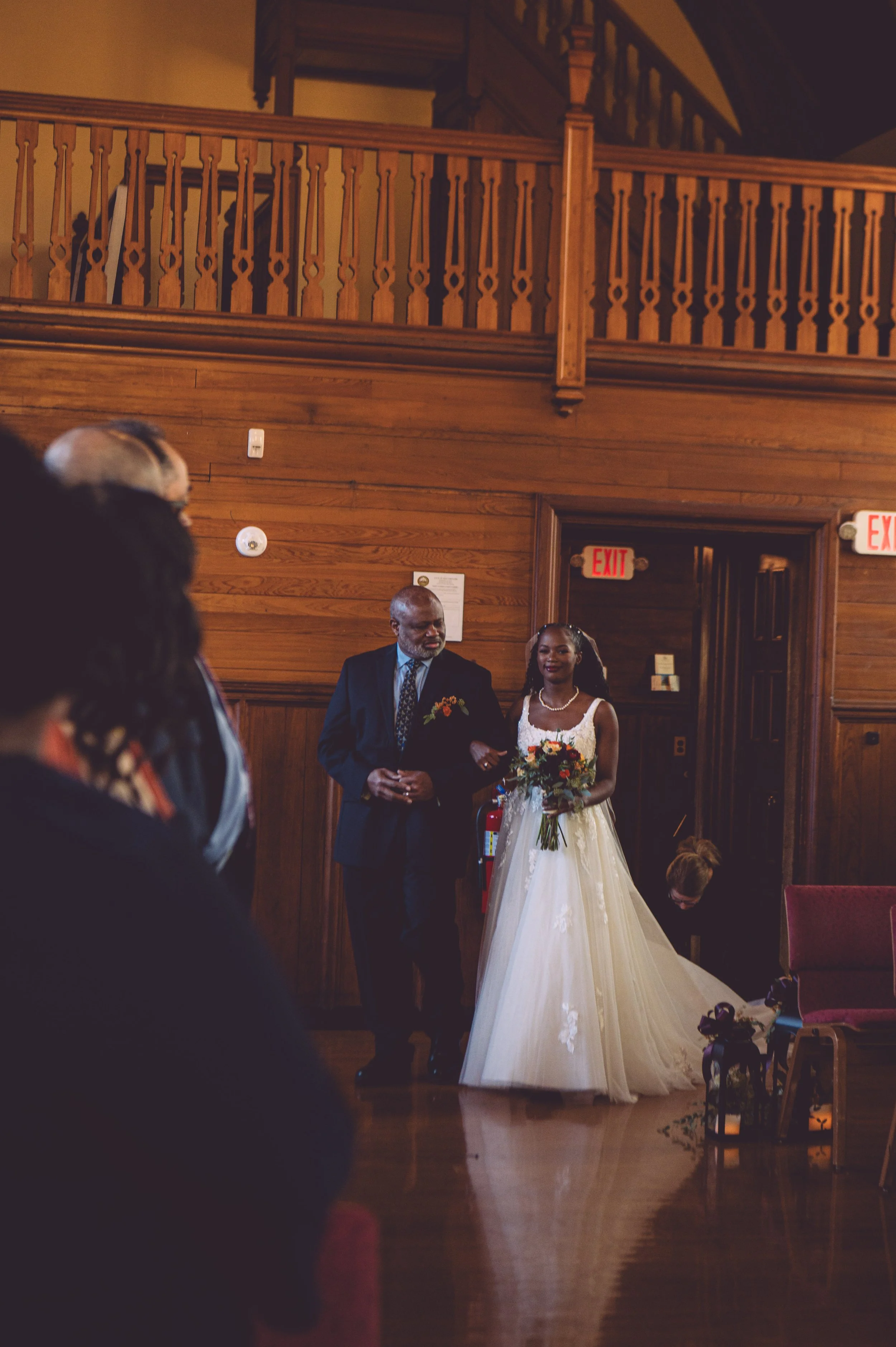 A stunning bride being escorted down the aisle by her proud father during her wedding at Searles Chapel in Windham, NH. Wedding photography by Mike Indi.