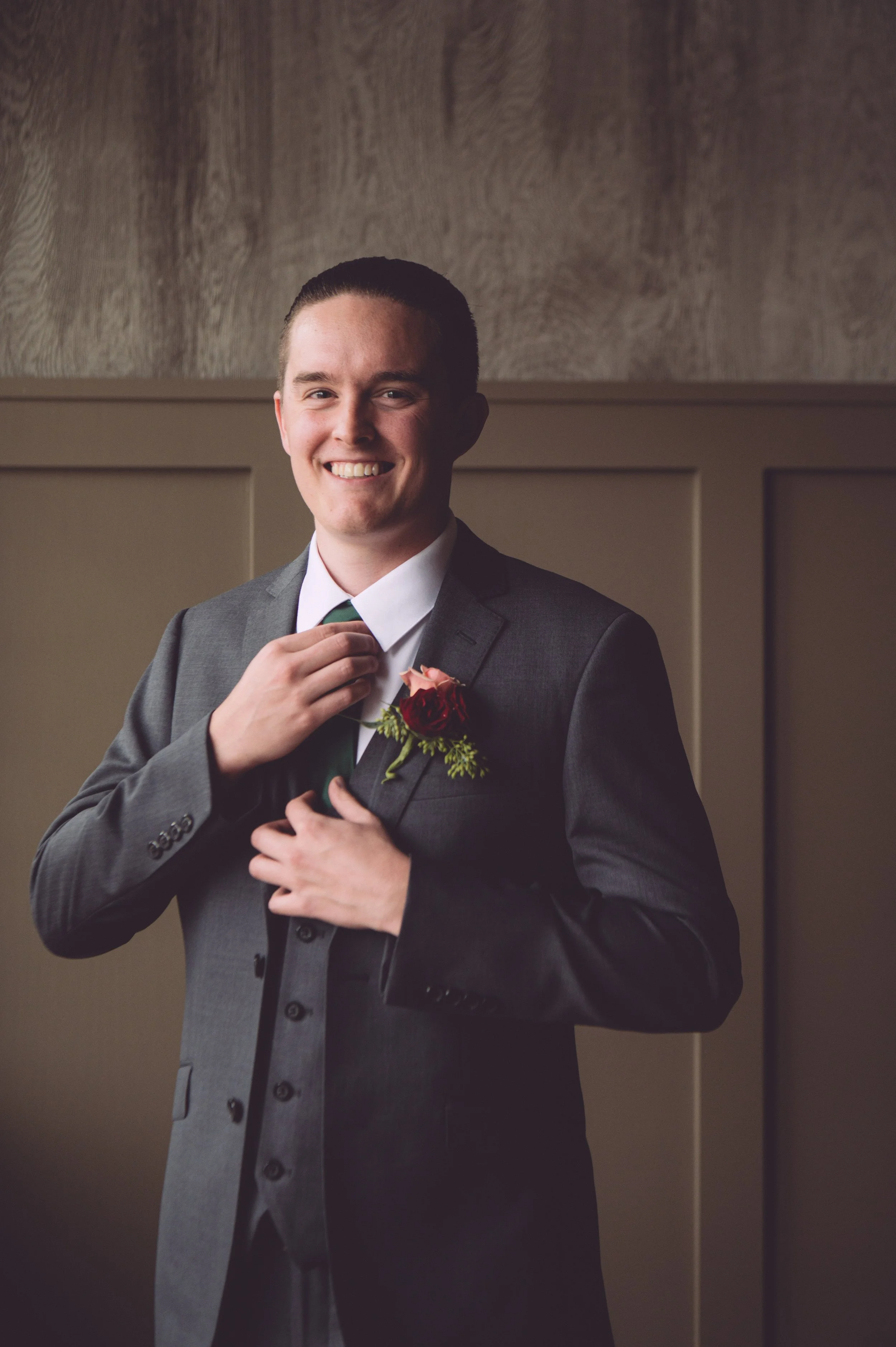 A handsome groom adjusting his tie while getting ready for his wedding at LaBelle Winery in Derry, NH. Wedding photography by Mike Indi.