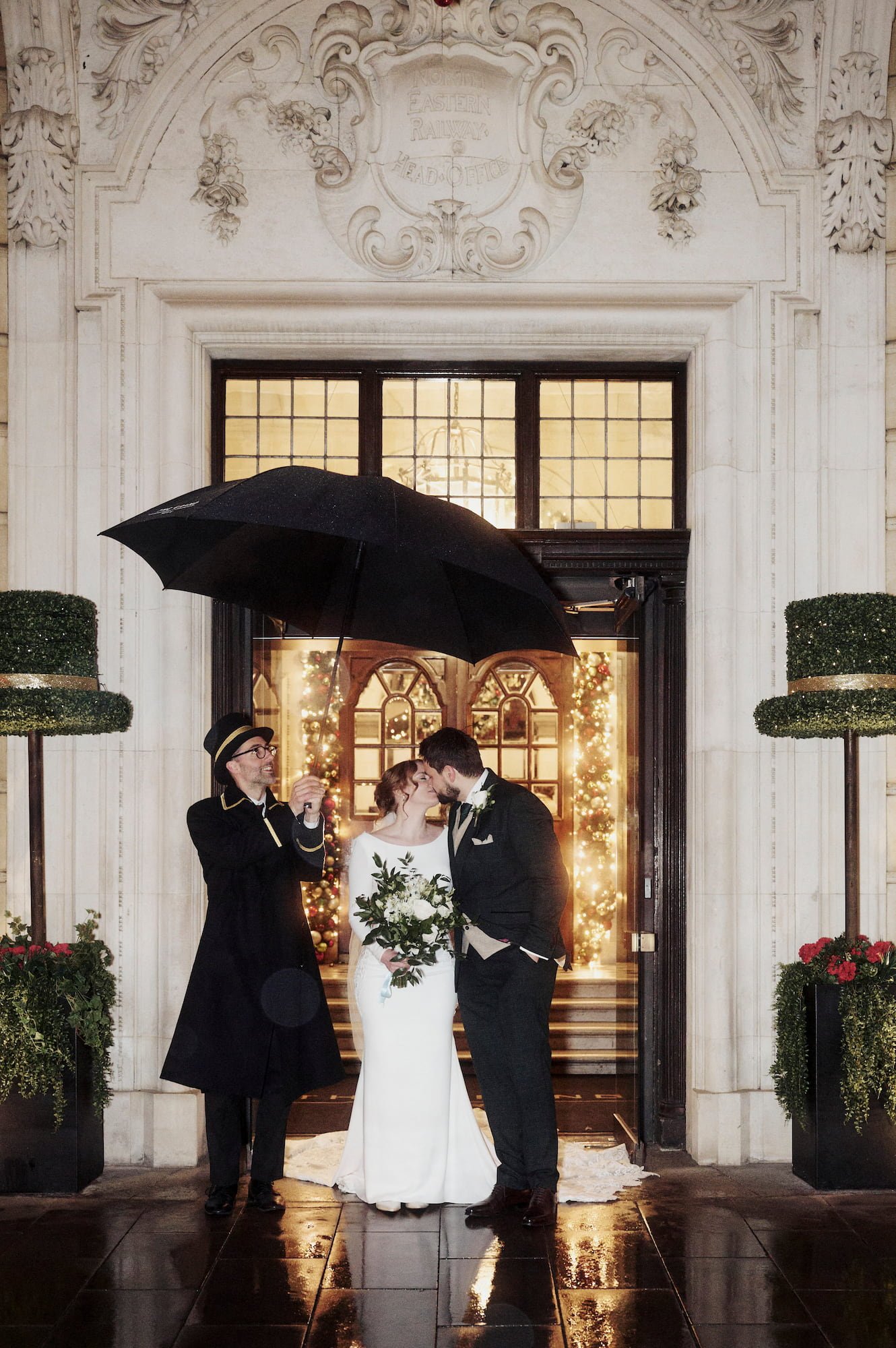 Newlyweds kissing by the Grand Hotel