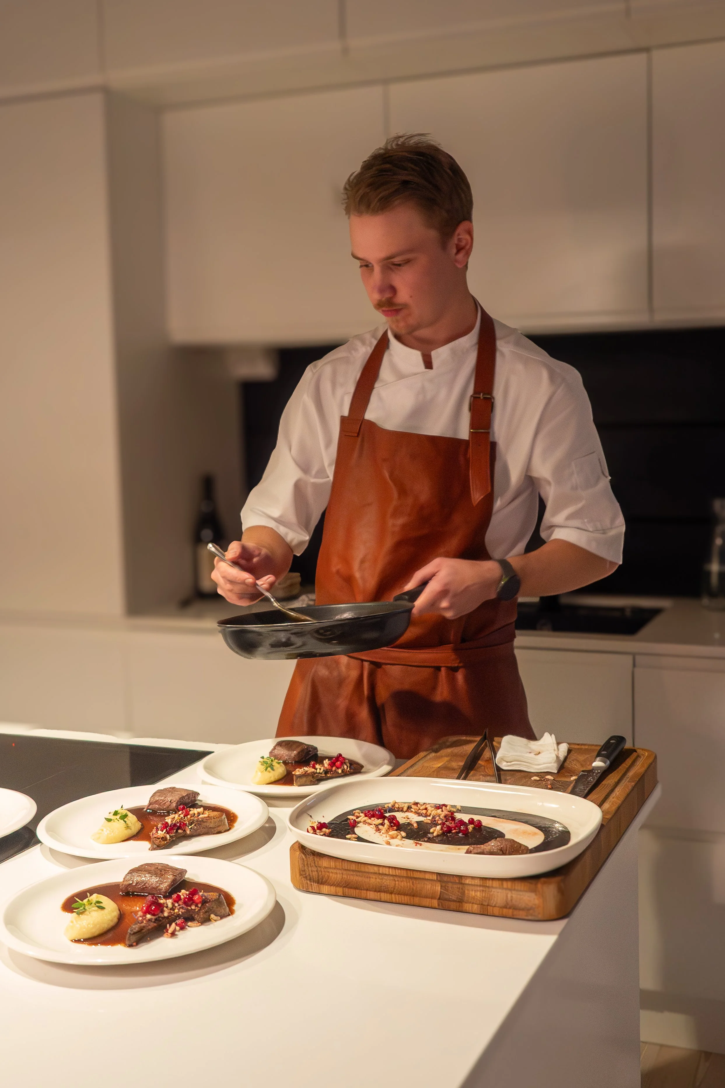Chef plating dishes in a modern kitchen.