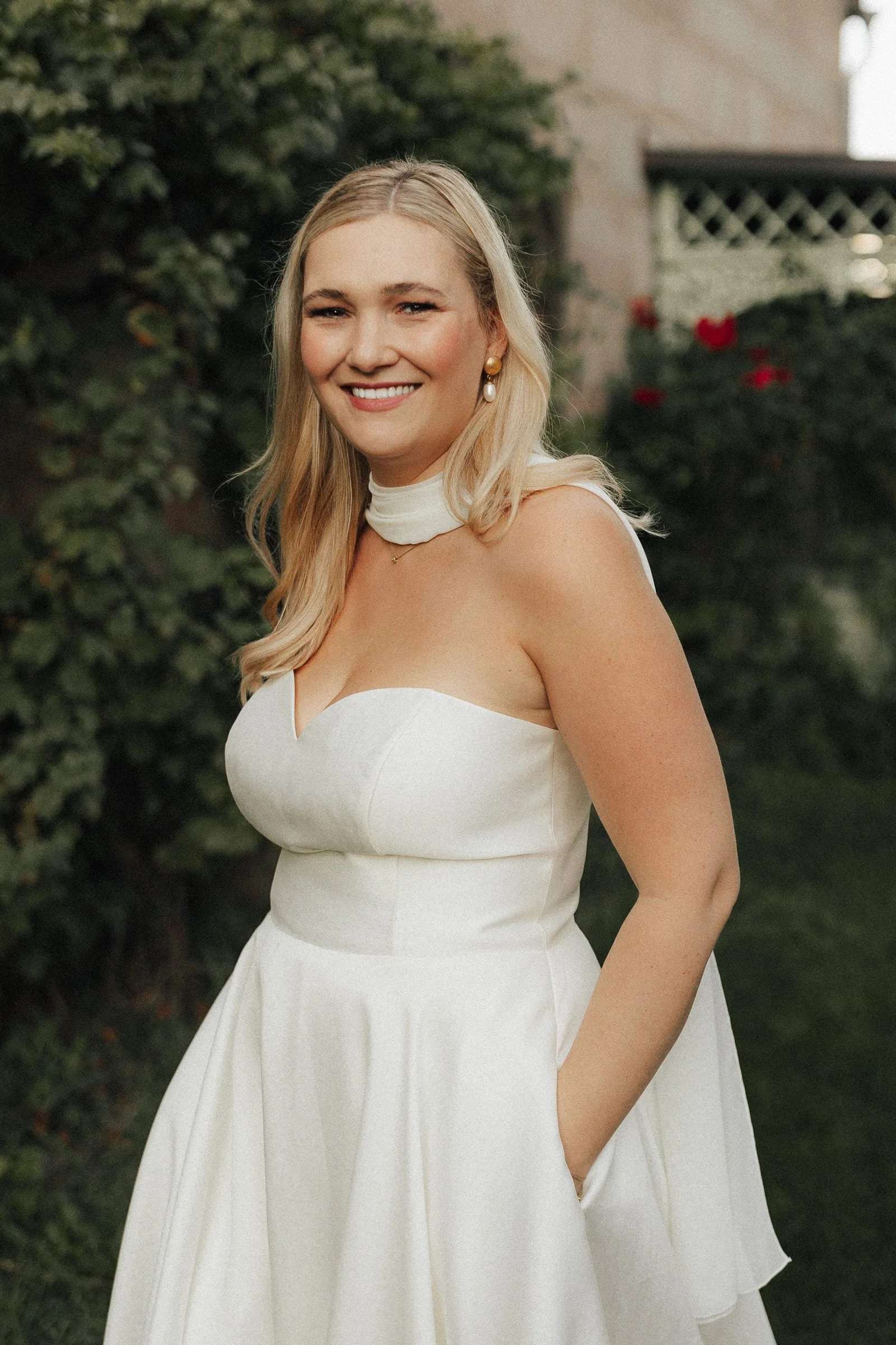 Junge Frau in weißem Kleid bei Sonnenschein im Garten von Schloss Dürrenmungenau.