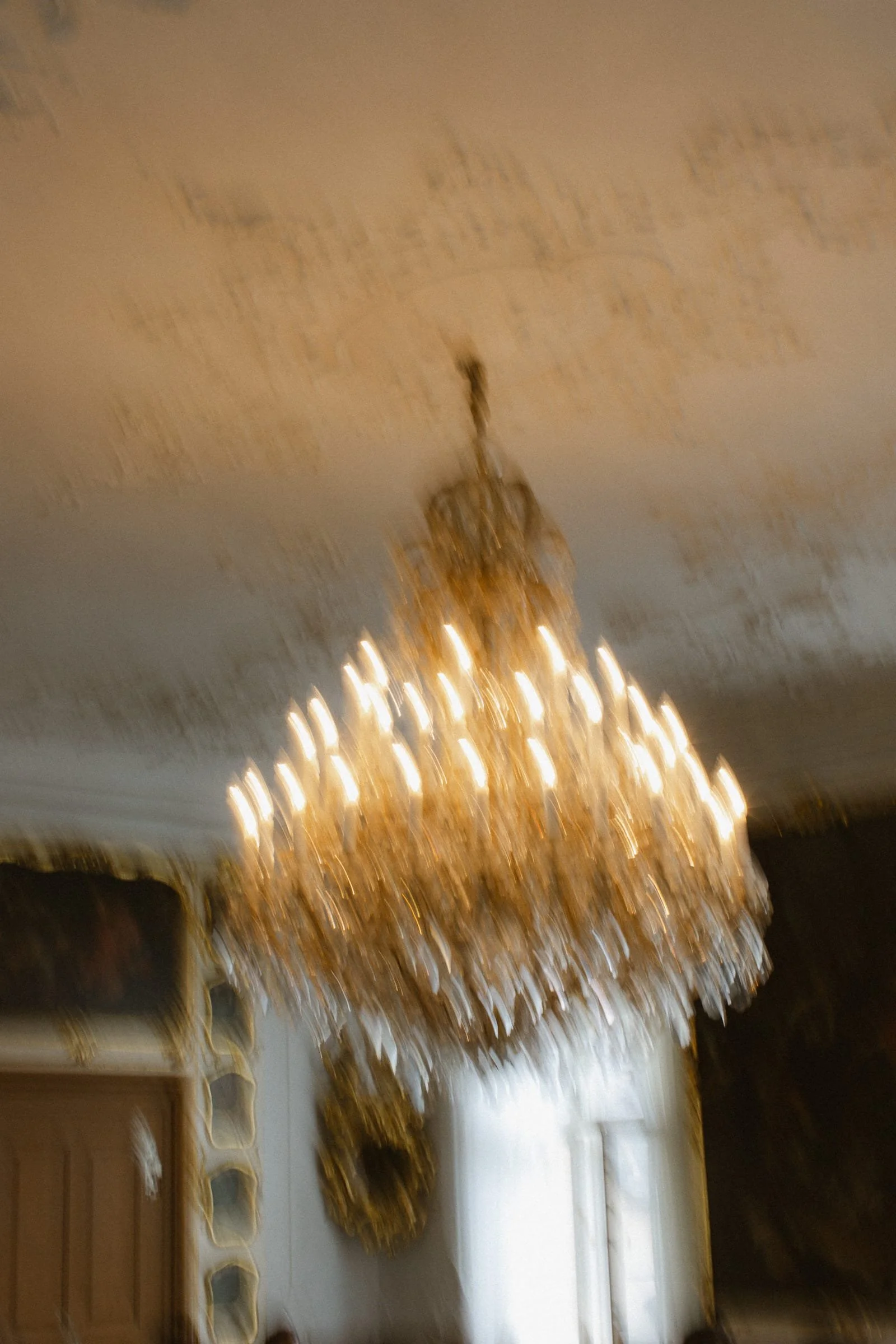 Ein große, goldene Kronleuchter hängt von der Decke im Alten Rathaus Bamberg.