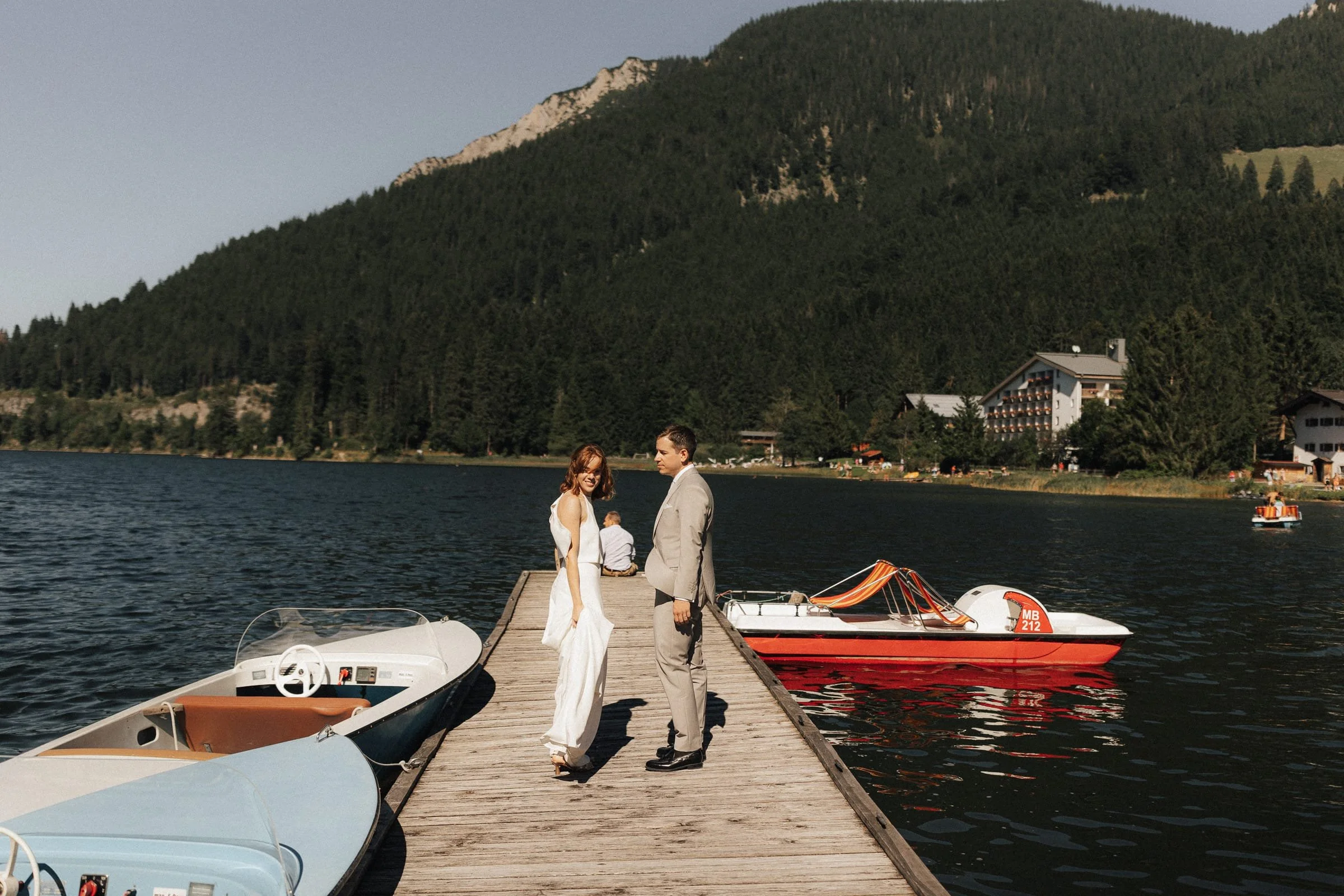 Stilvolles Porträt von Brautpaar am Steg am Schliersee mit Bergsilhouette