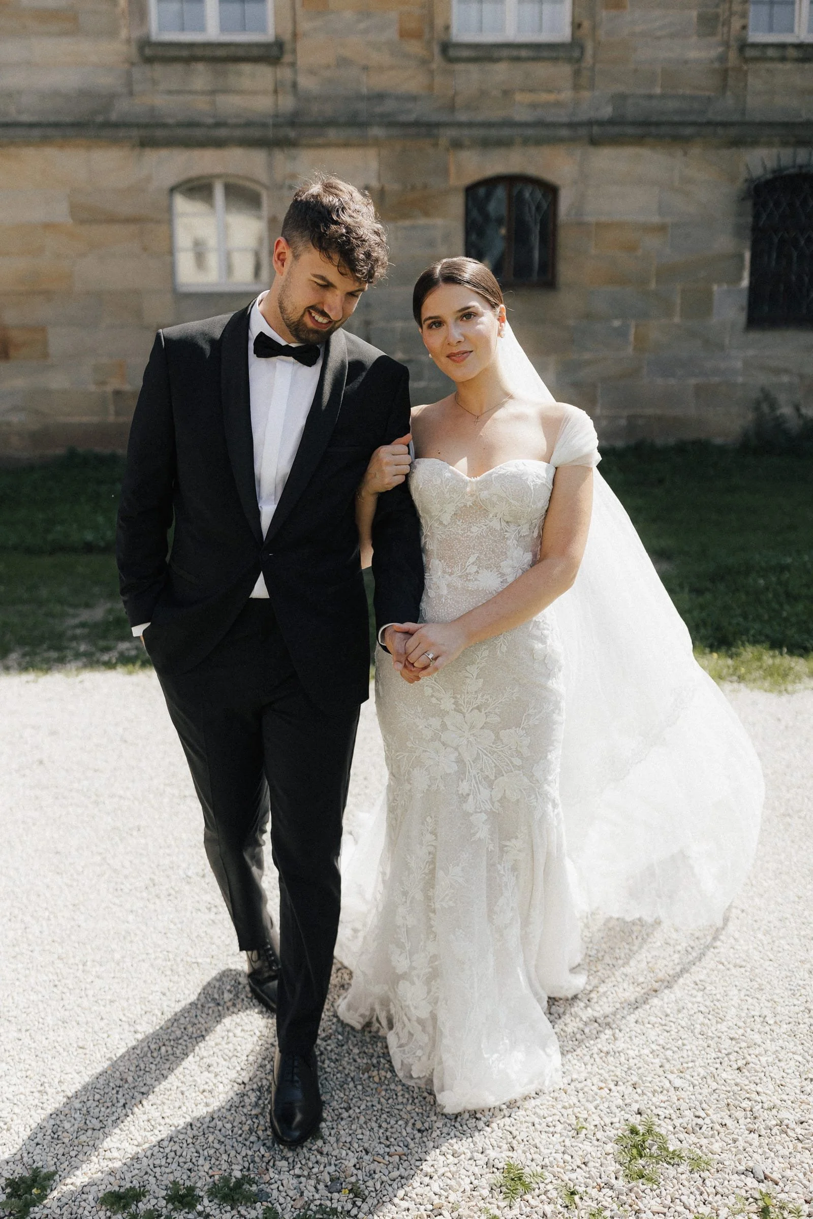 Zeitlose Hochzeitsfotografie eines Brautpaares in klassischer Eleganz vor altem Gemäuer