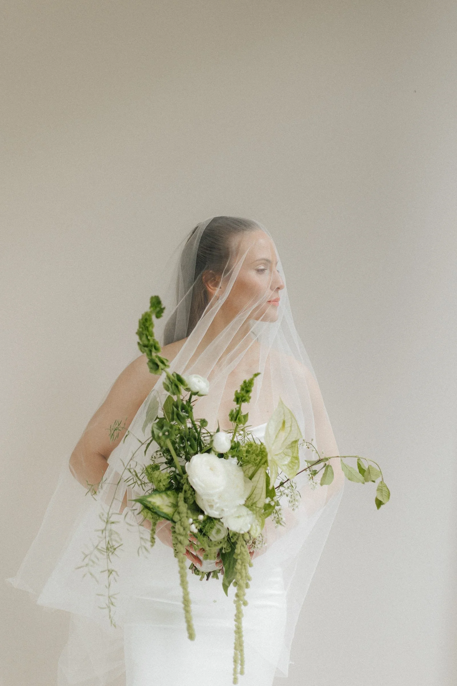 Braut mit Schleier hält einen weißen Blumenstrauß auf der Terrasse der Stadtvilla Nürnberg.