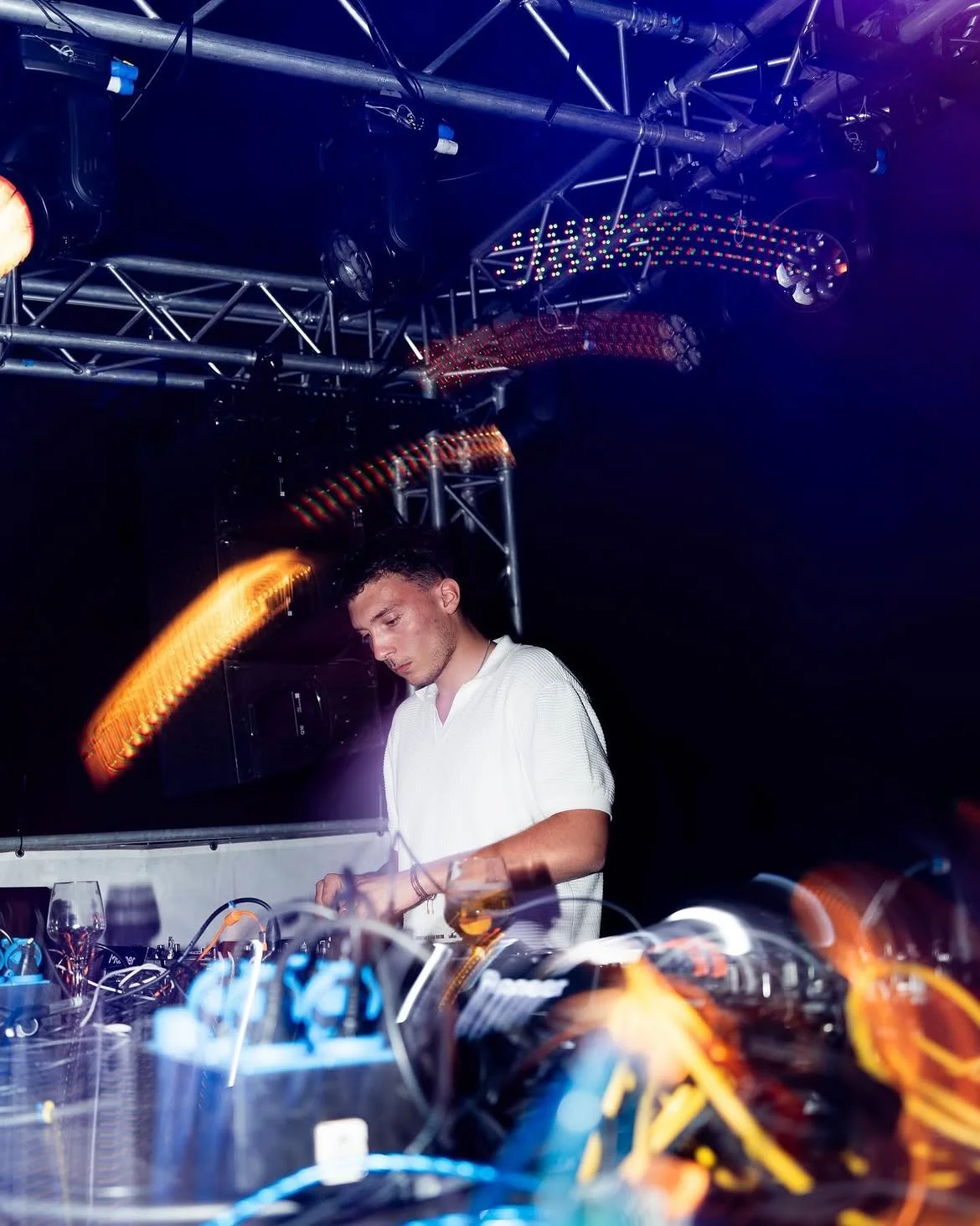 DJ Wintset mixant dans un club avec des lumières colorées et un décor électronique.